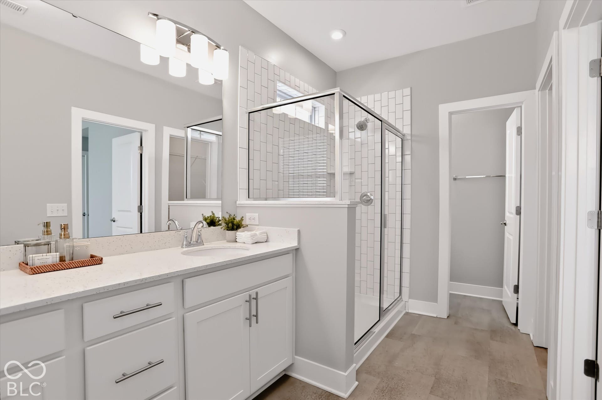 Double vanity with white cabinetry, quartz countertop, and undermount sinks