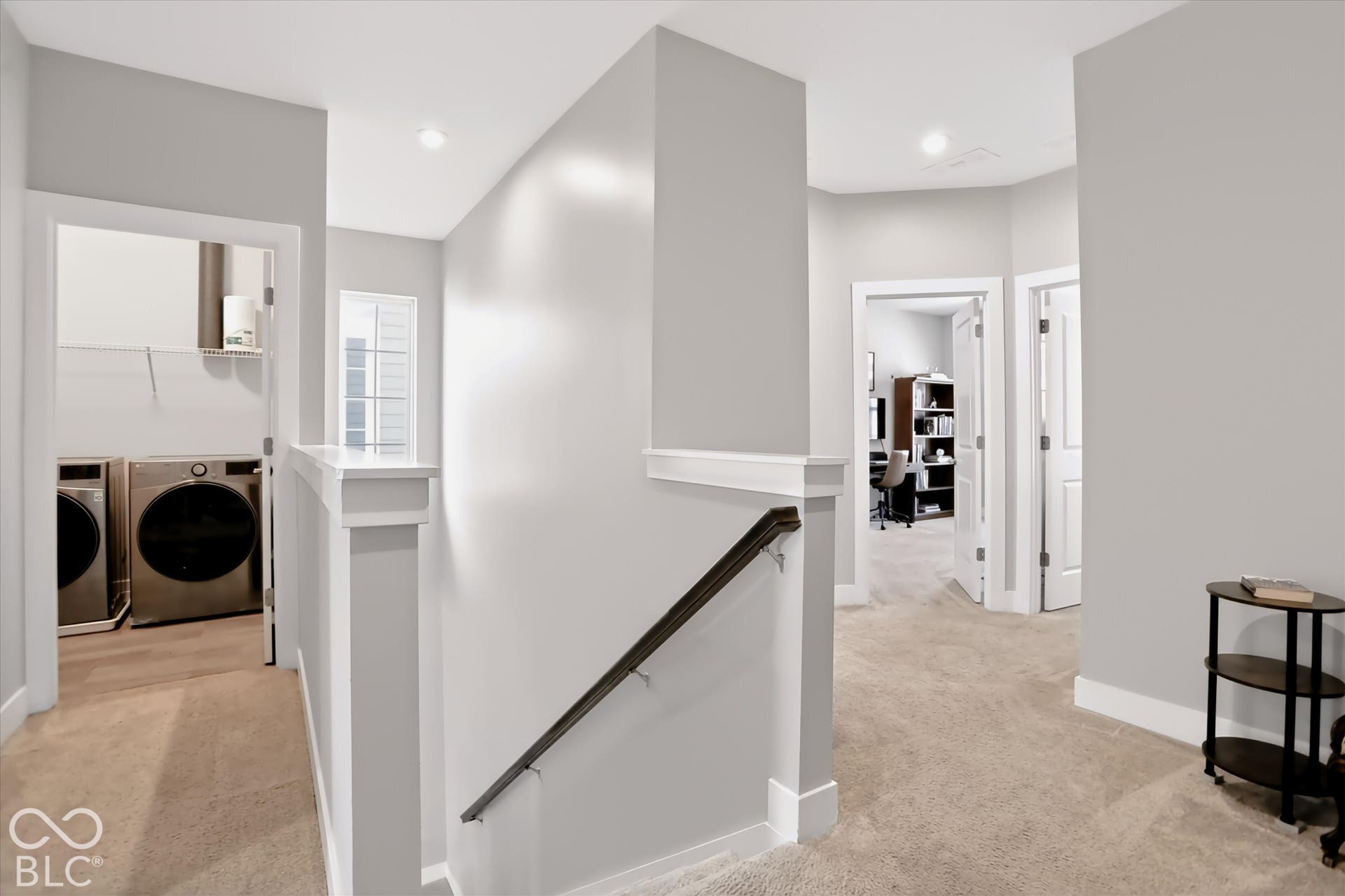 Hallway with neutral carpeting, white trim, and light gray wall paint
