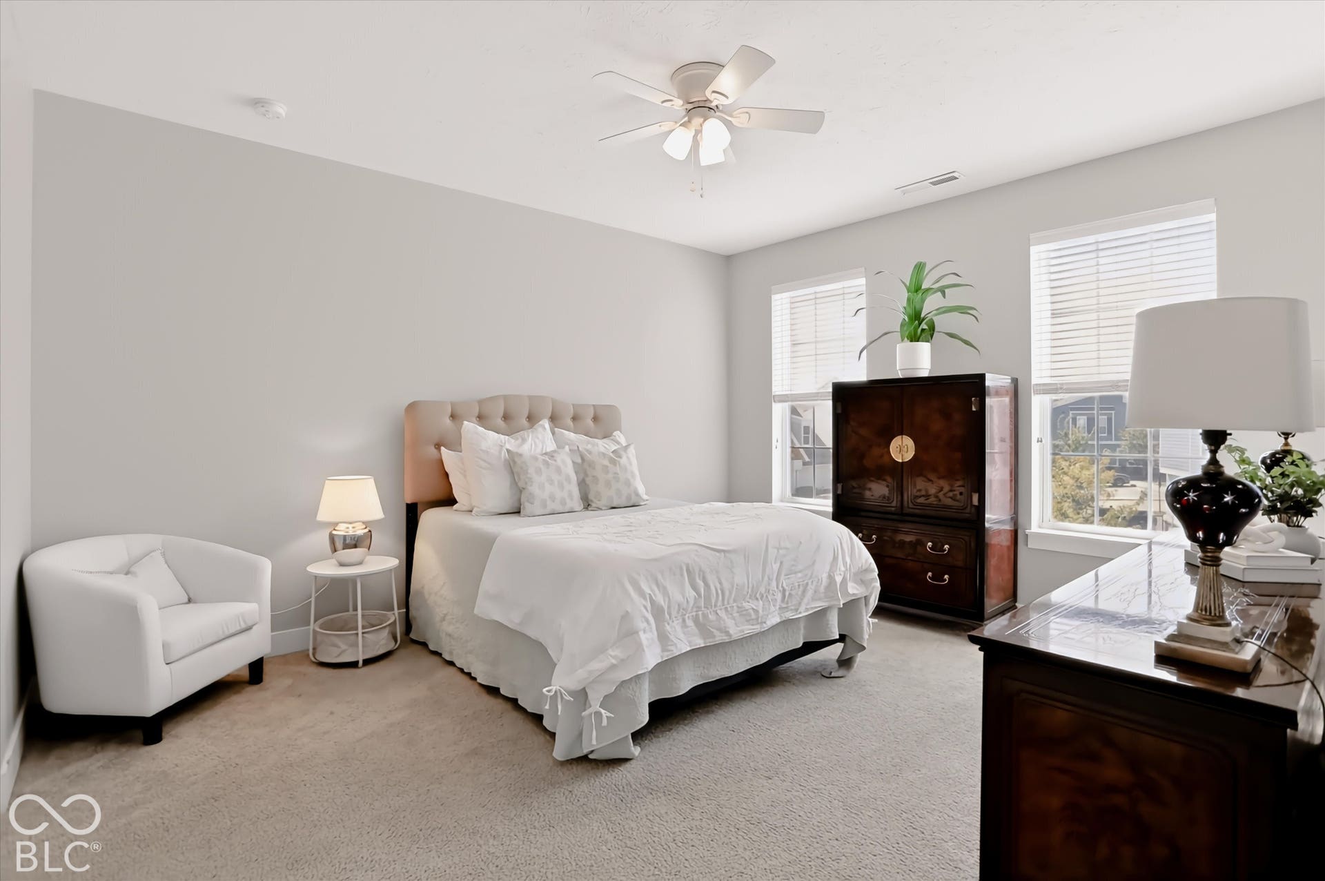 Plush carpeting, a built-in ceiling fan, light-toned walls, and multiple windows with blinds
