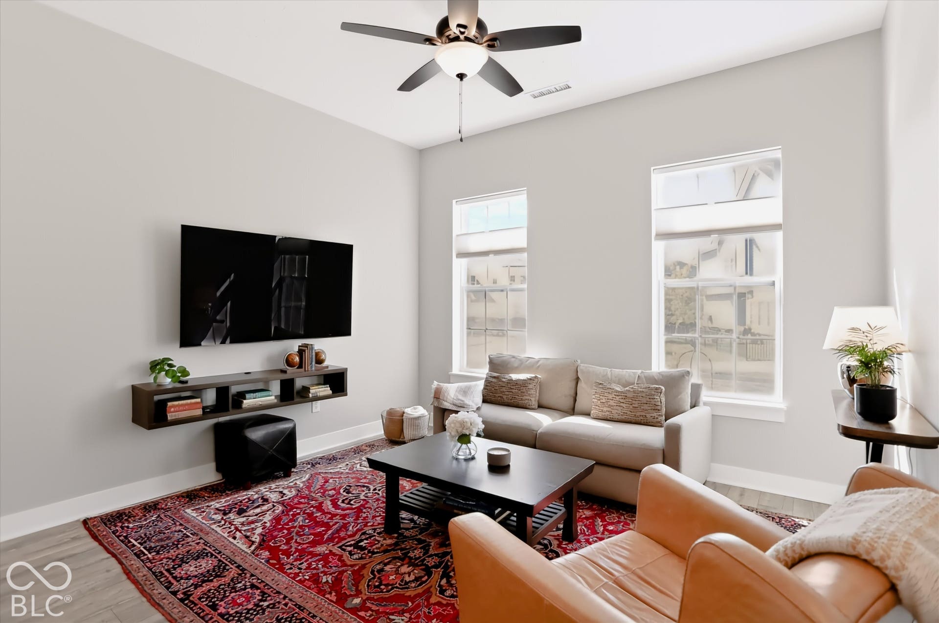 Recessed lighting, ceiling fan, two large windows, and light wood-finish flooring