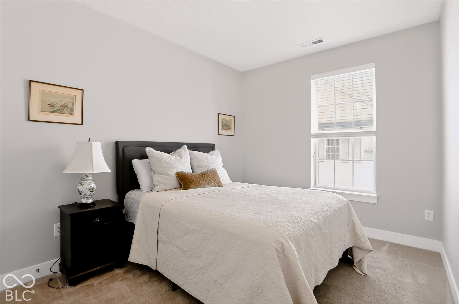 Light gray walls with white trim, a single window with blinds, and carpeted flooring