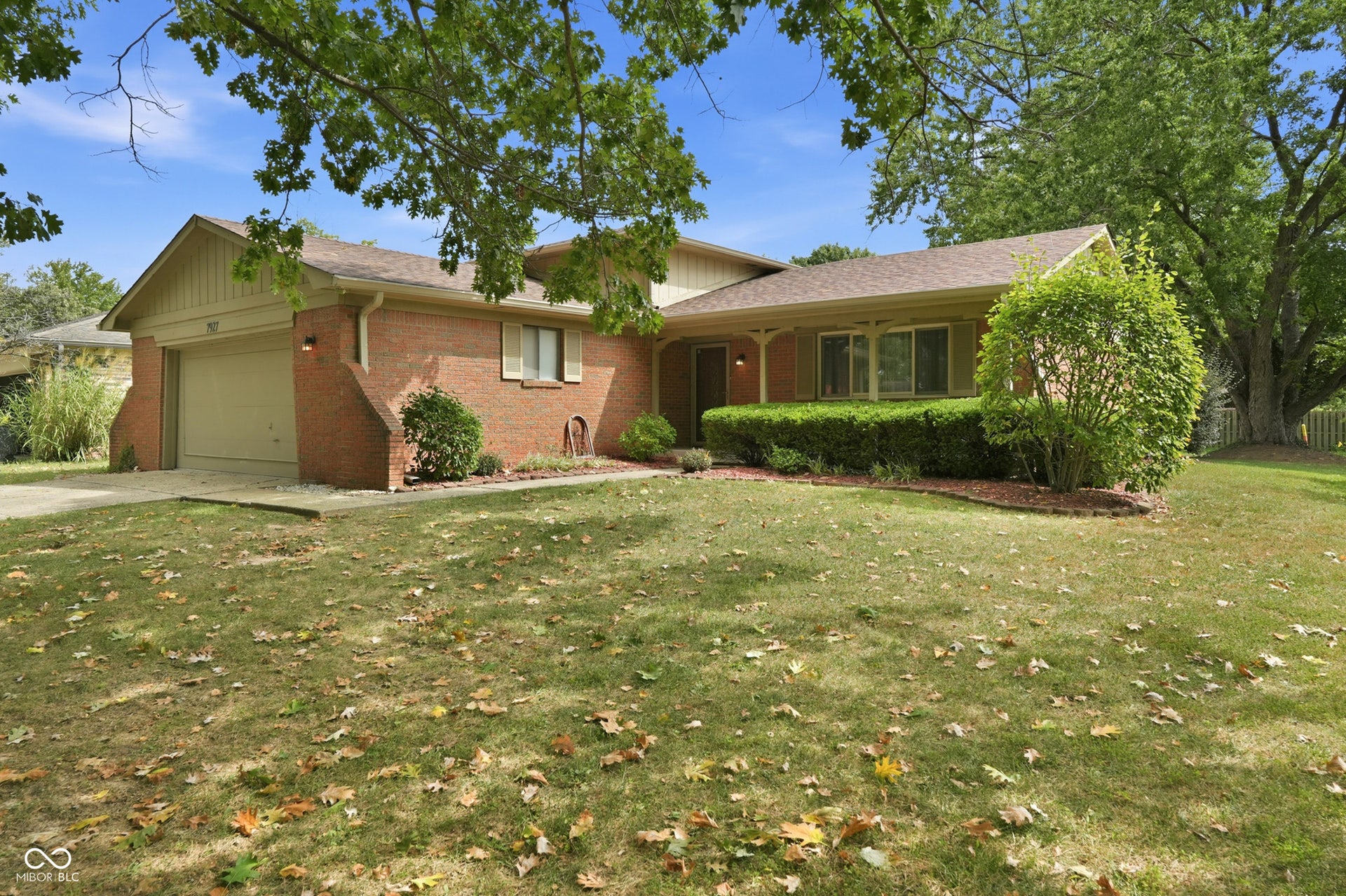 7927 Hoop Road, Indianapolis, IN 46217 Brick exterior facade with an attached garage, covered entryway, and front landscaping