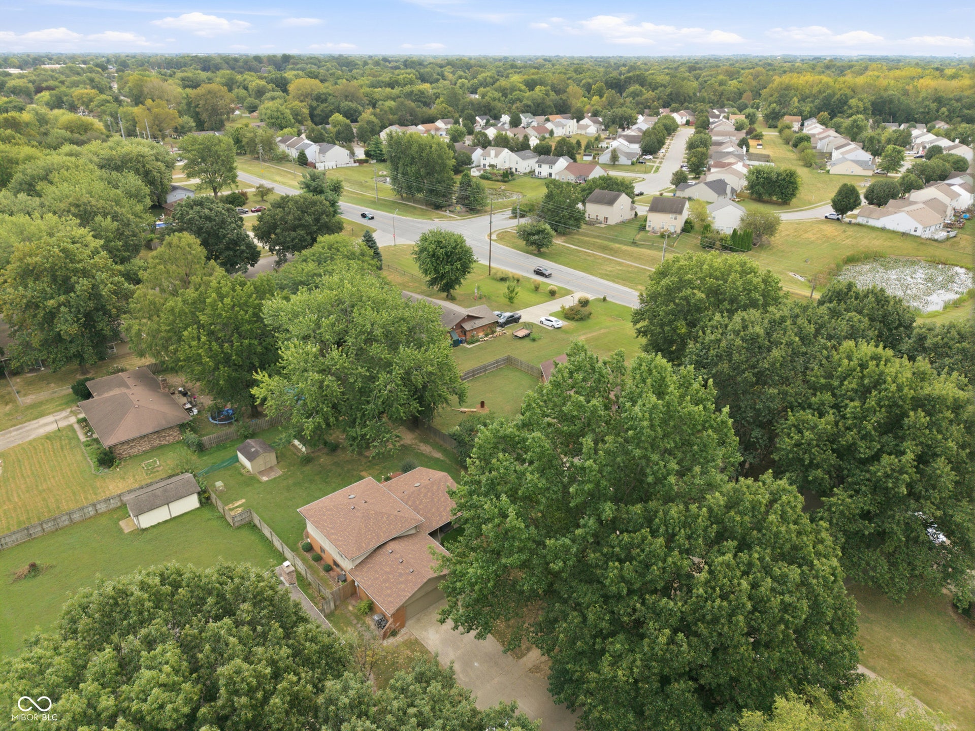 7927 Hoop Road, Indianapolis, IN 46217 Neighborhood setting featuring established residences, mature trees, and a pond