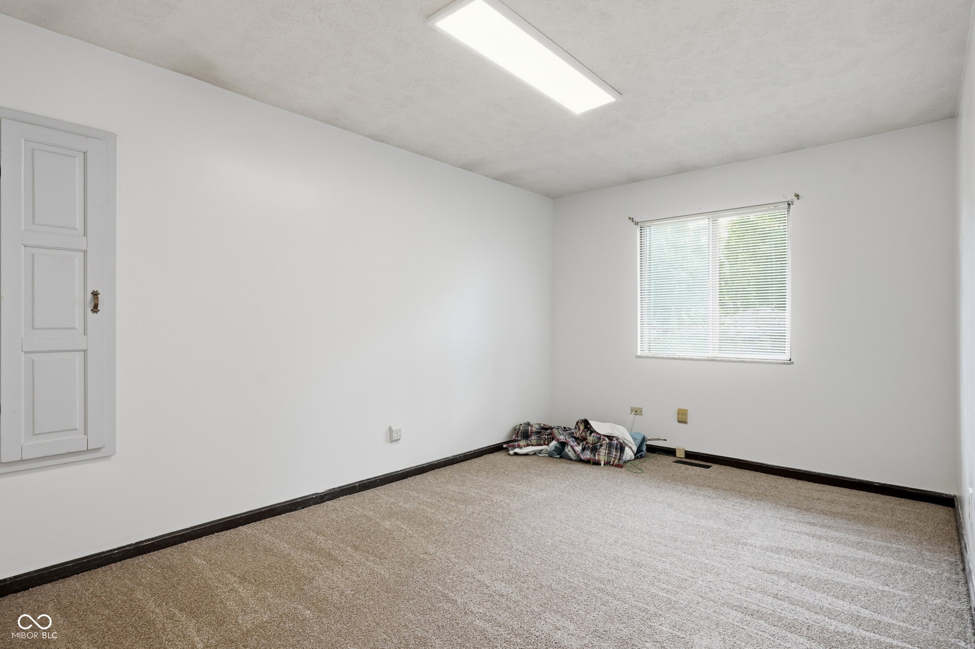 7927 Hoop Road, Indianapolis, IN 46217 Upper level bedroom 2, window with blinds, white painted walls, textured ceiling, fluorescent lighting fixture, and carpet flooring