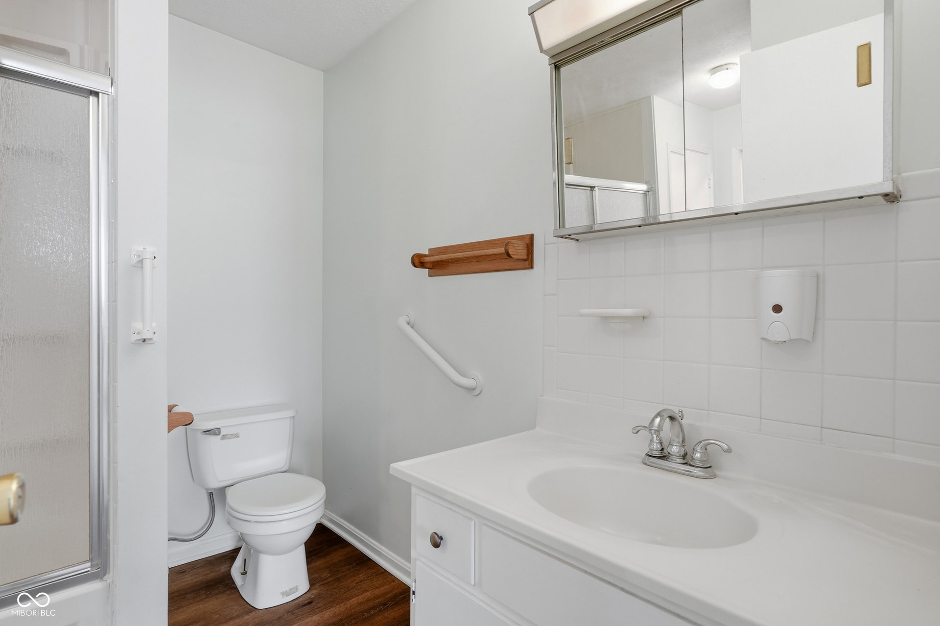 7927 Hoop Road, Indianapolis, IN 46217 Upper level full bath, white vanity with an integrated sink and chrome faucet, complemented by a mirrored medicine cabinet and white tile backsplash
