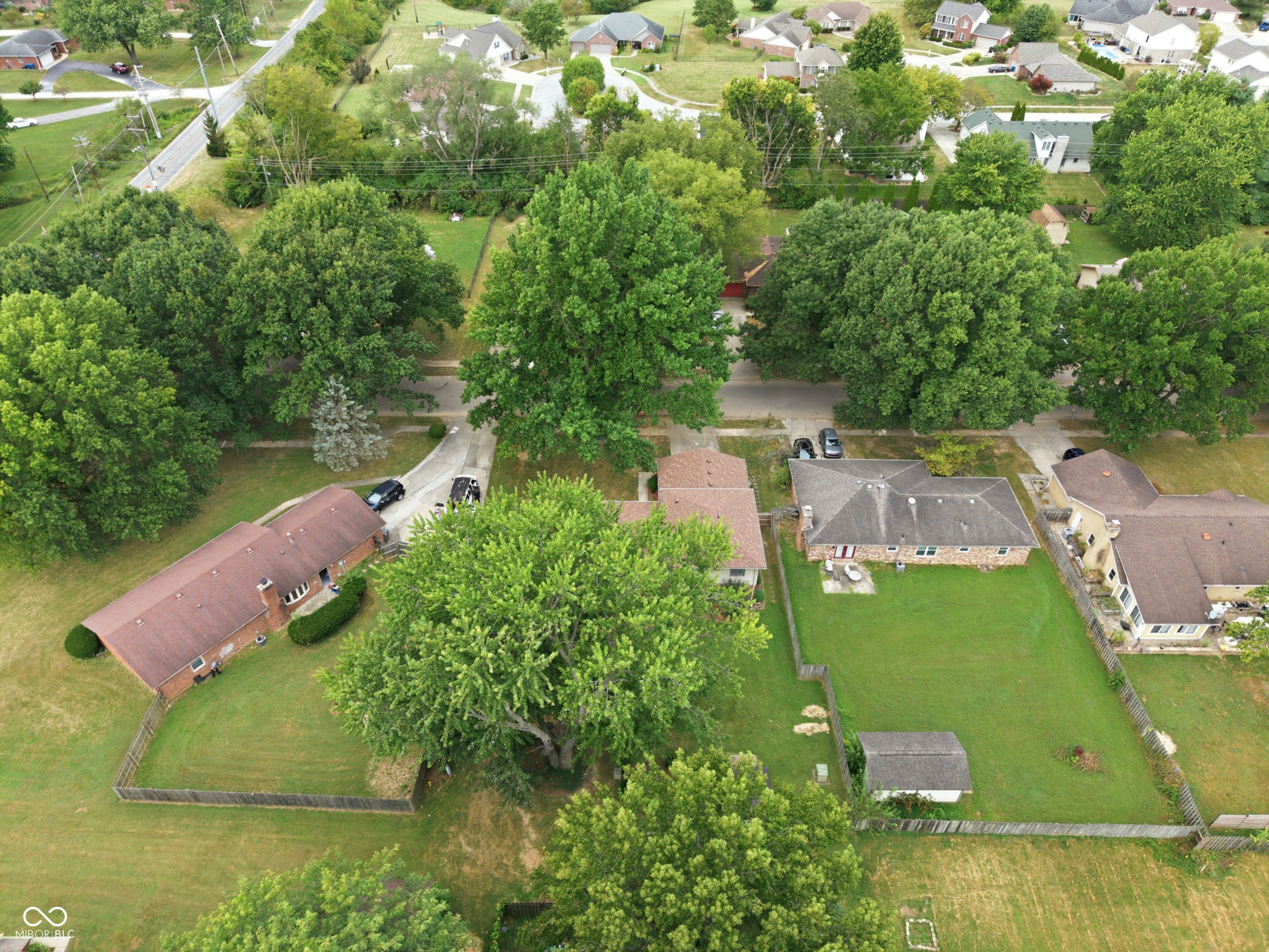 7927 Hoop Road, Indianapolis, IN 46217 Expansive property with mature trees, fenced backyard, and a detached storage shed
