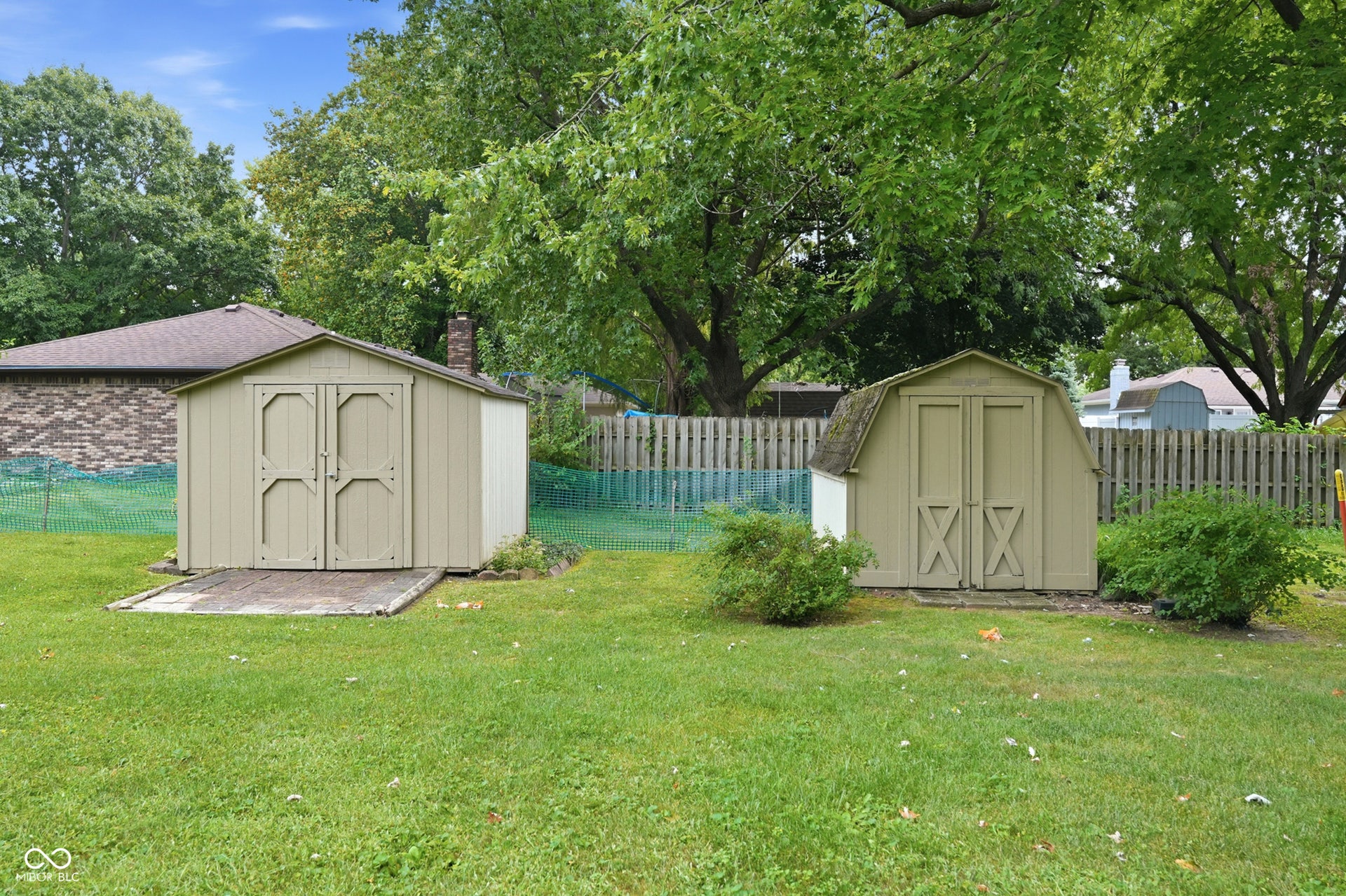 7927 Hoop Road, Indianapolis, IN 46217 Expansive green lawn featuring two storage sheds and mature trees