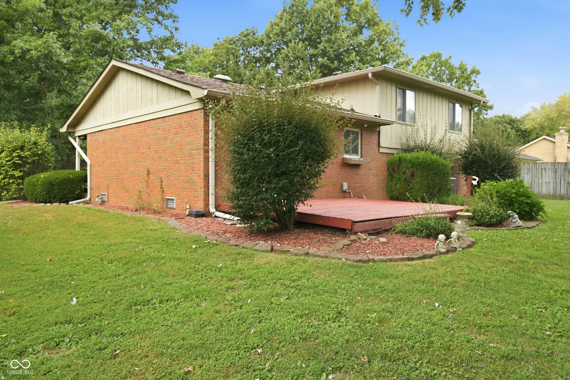 7927 Hoop Road, Indianapolis, IN 46217 Expansive backyard featuring a wood deck, brick exterior, and mature landscaping