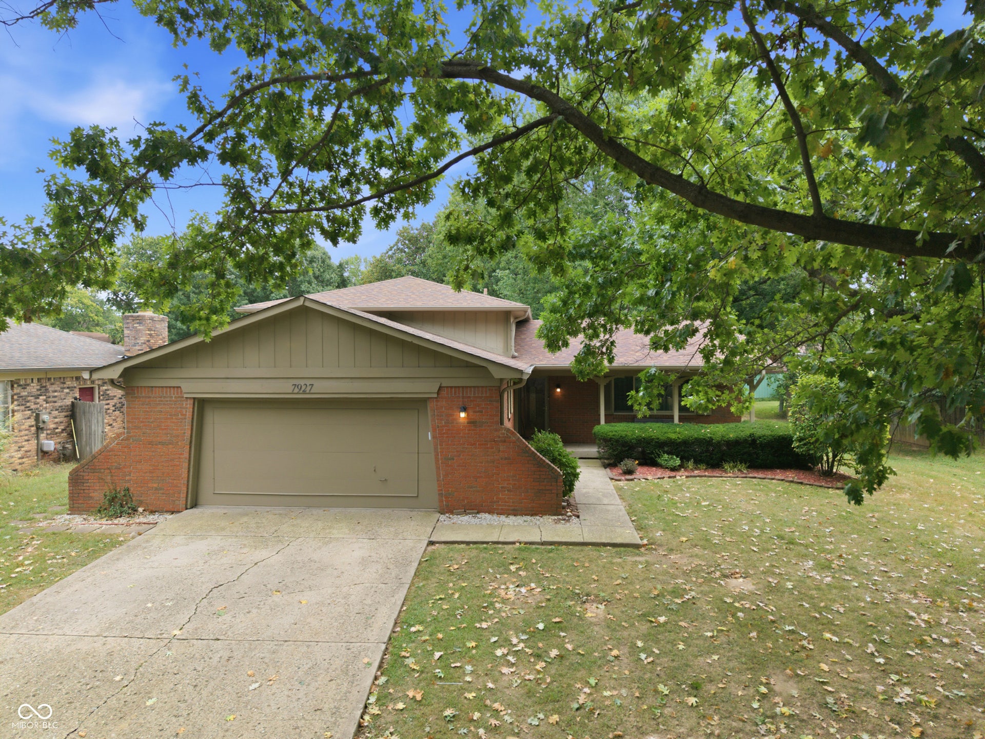 7927 Hoop Road, Indianapolis, IN 46217 Brick and siding exterior with an attached garage and concrete driveway