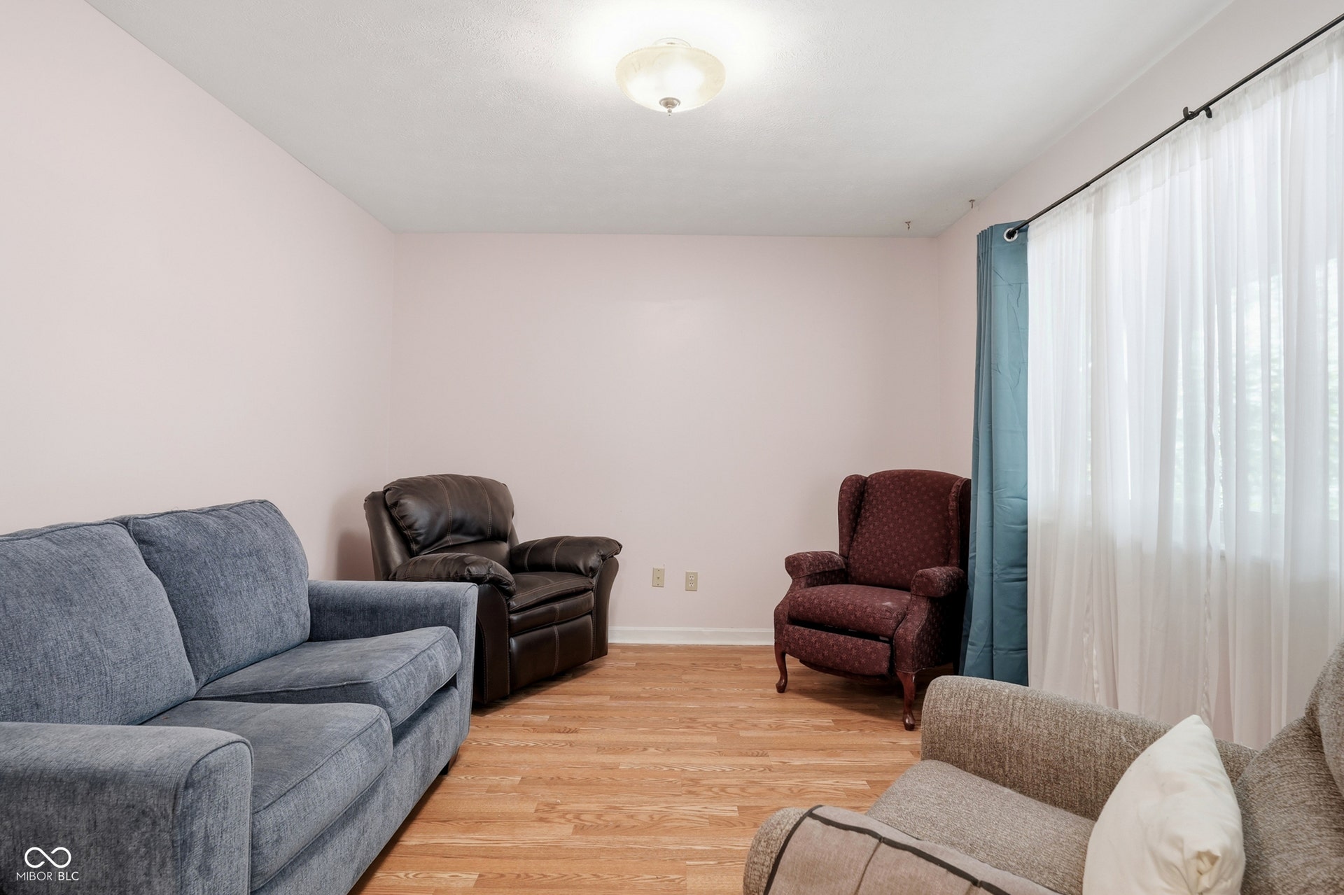 7927 Hoop Road, Indianapolis, IN 46217 Neutral wall color, wood-finish laminate flooring, and natural light from a window with curtains