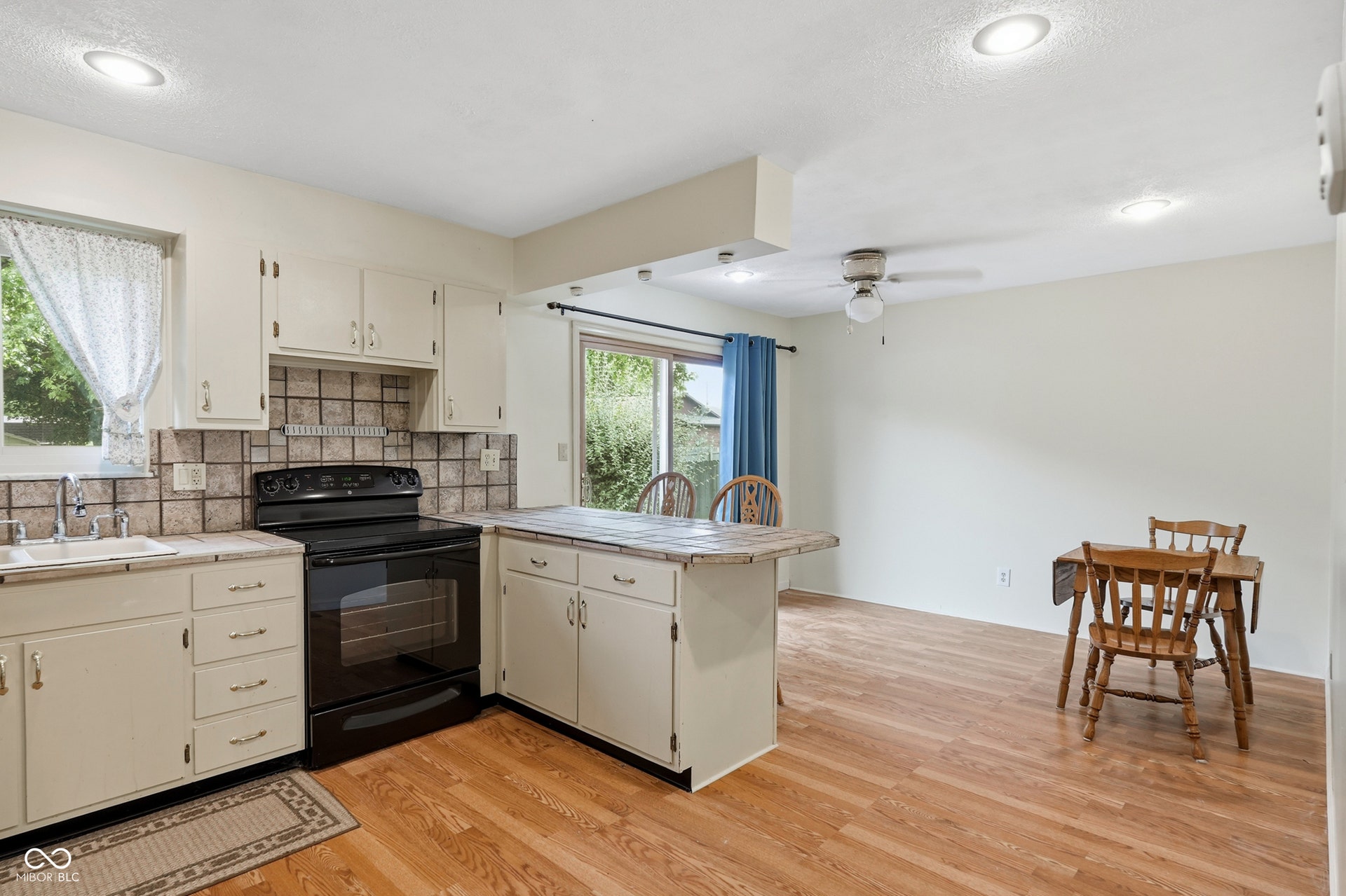 7927 Hoop Road, Indianapolis, IN 46217 Kitchen with white cabinetry, tile backsplash, laminate countertops, and a black electric range
