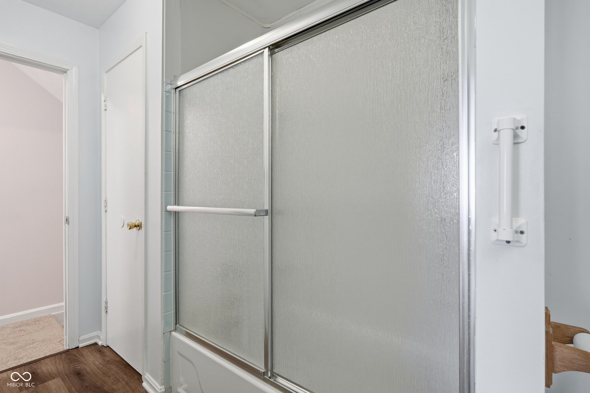 7927 Hoop Road, Indianapolis, IN 46217 Upper level full bath, bathtub with sliding shower doors and a grab bar