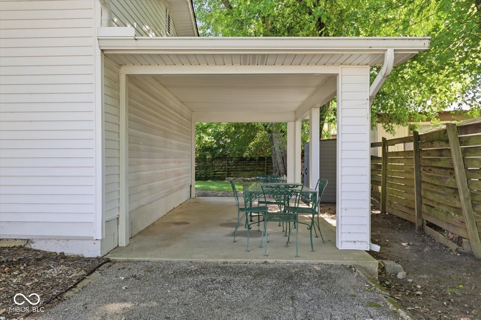 Virtually Altered - Covered porch with concrete flooring and white siding