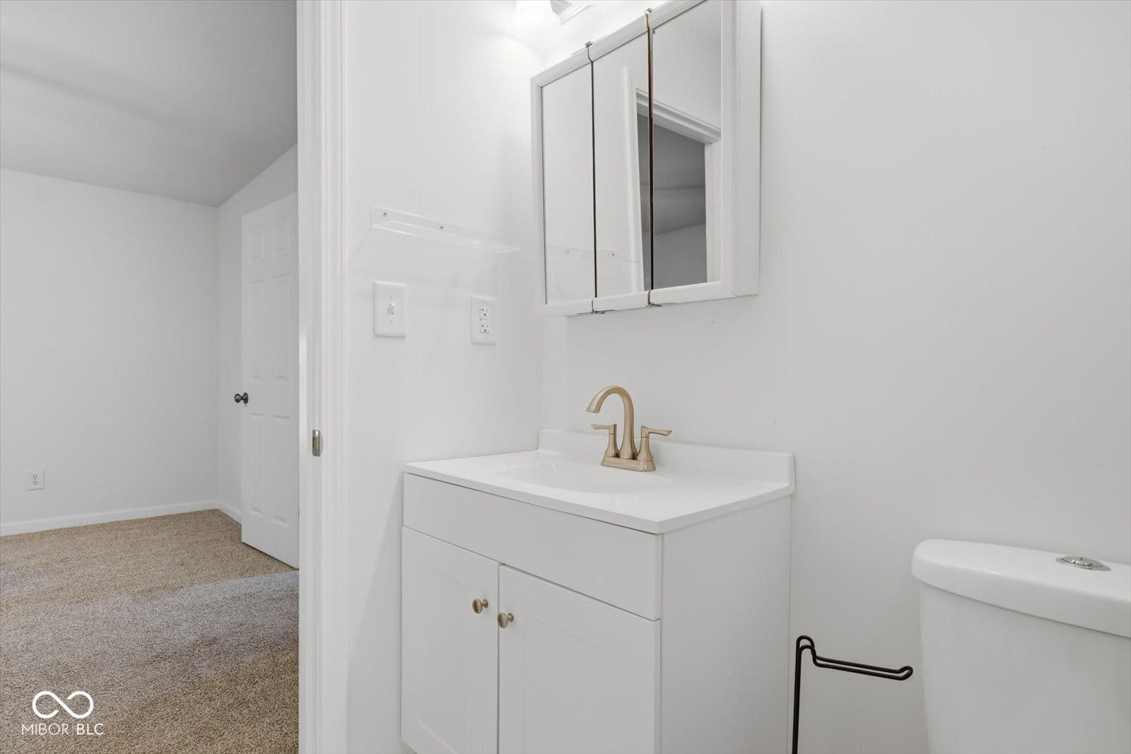 Bathroom vanity with an integrated sink and a brass-finish faucet