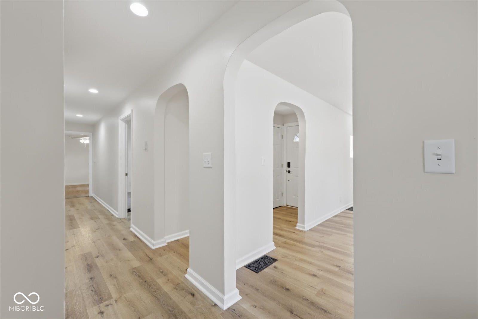 Light wood-finish flooring throughout, complemented by white walls and recessed ceiling lighting