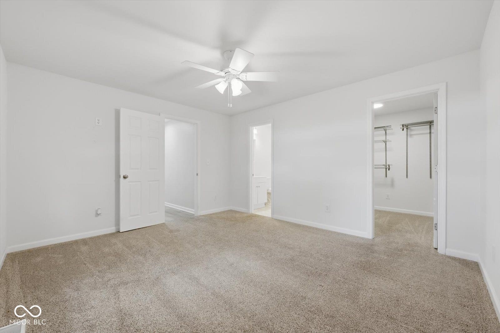 Plush carpet flooring, white walls, ceiling fan, and access to an adjoining room and closet