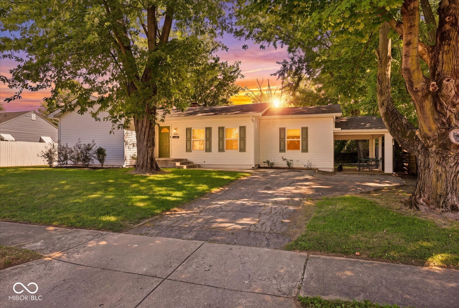 Virtually Altered - White siding exterior with dark green shutters, an attached carport, and a paved driveway