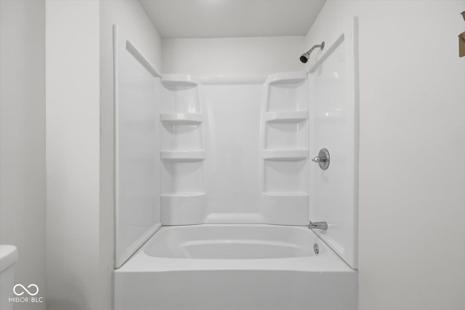 White shower/tub combination with integrated shelving