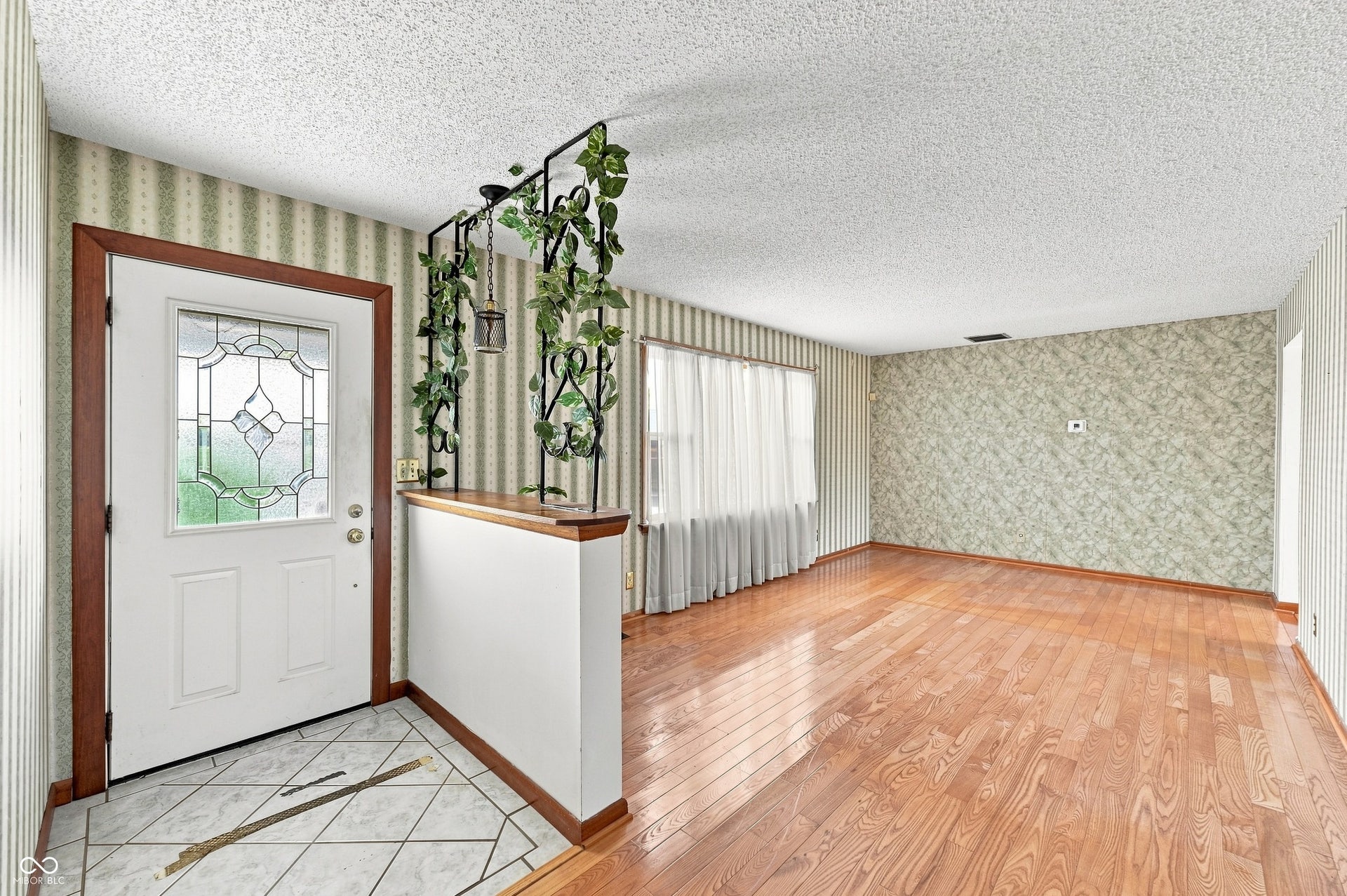Just inside from the covered porch is a tiled entry way and 23 x 13 Living Room with hardwood floors.