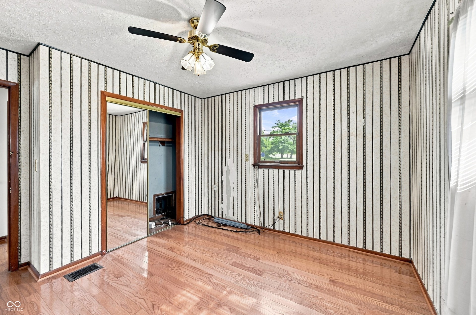 12 x11 Primary Bedroom with hardwood floors and ample closet space.