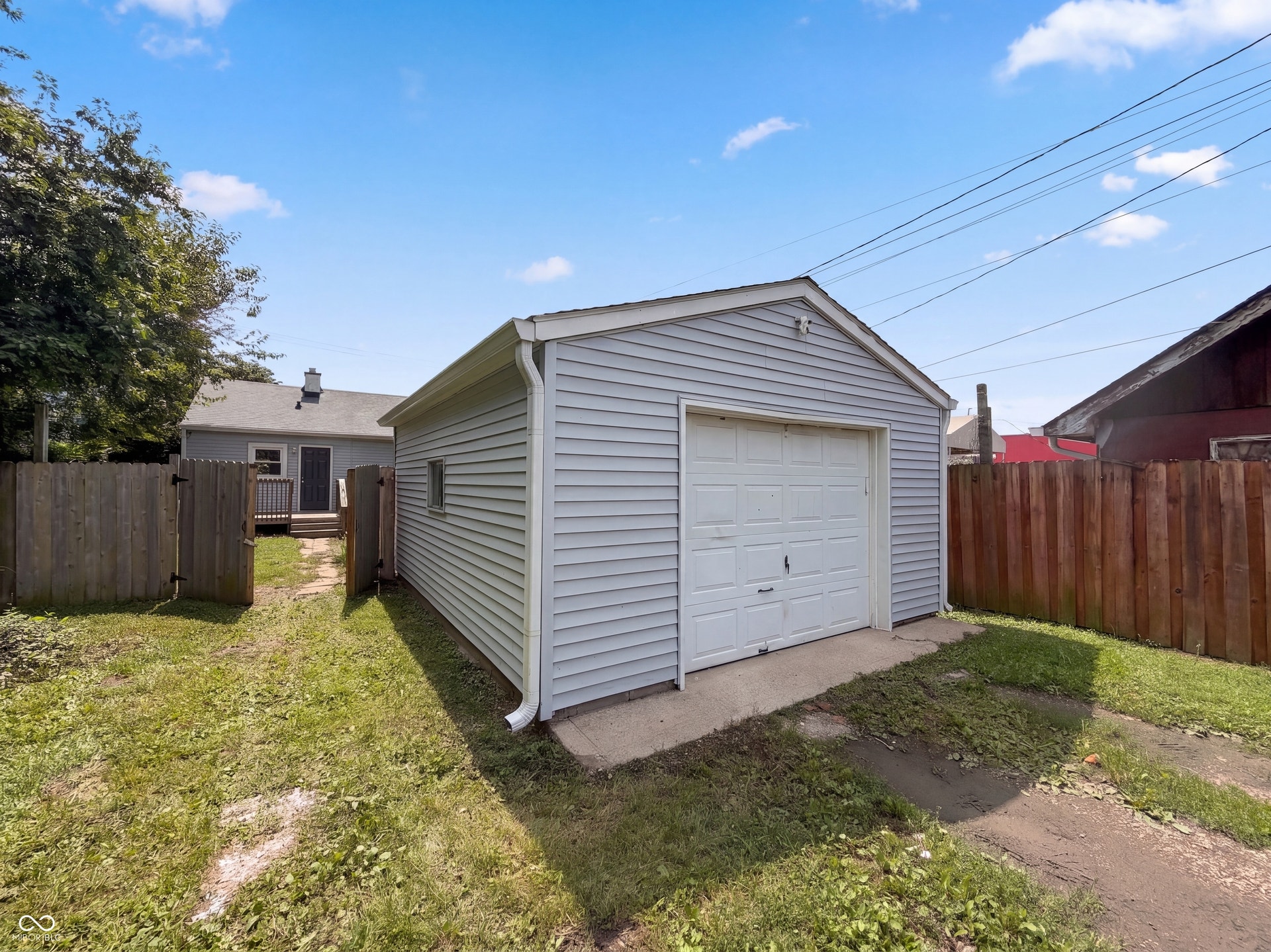 Detached garage featuring horizontal siding and a panel-style garage door