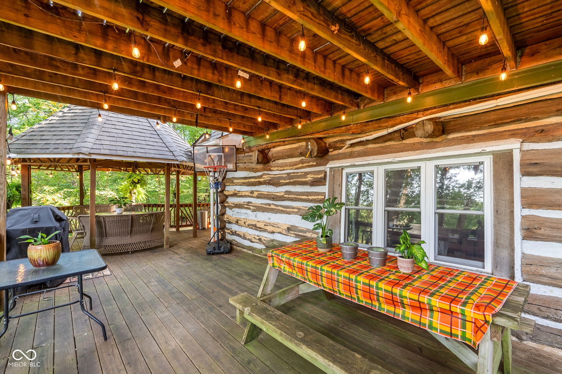 Expansive outdoor deck with wood flooring and exposed wood ceiling beams