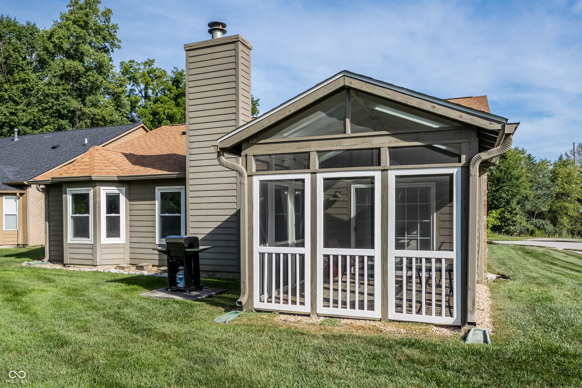 Screened porch with high ceilings, exterior siding, and a bay window