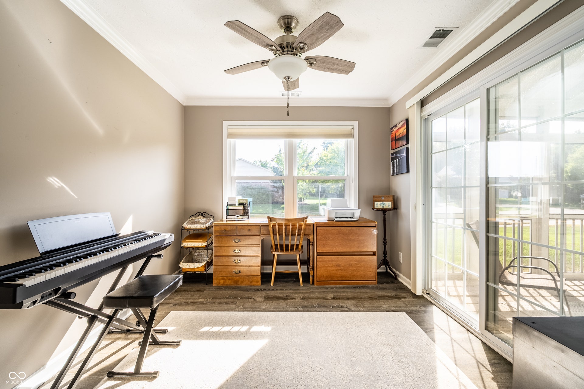 LVP flooring, crown molding, a ceiling fan with light fixture, and a sliding glass door to a screened in porch