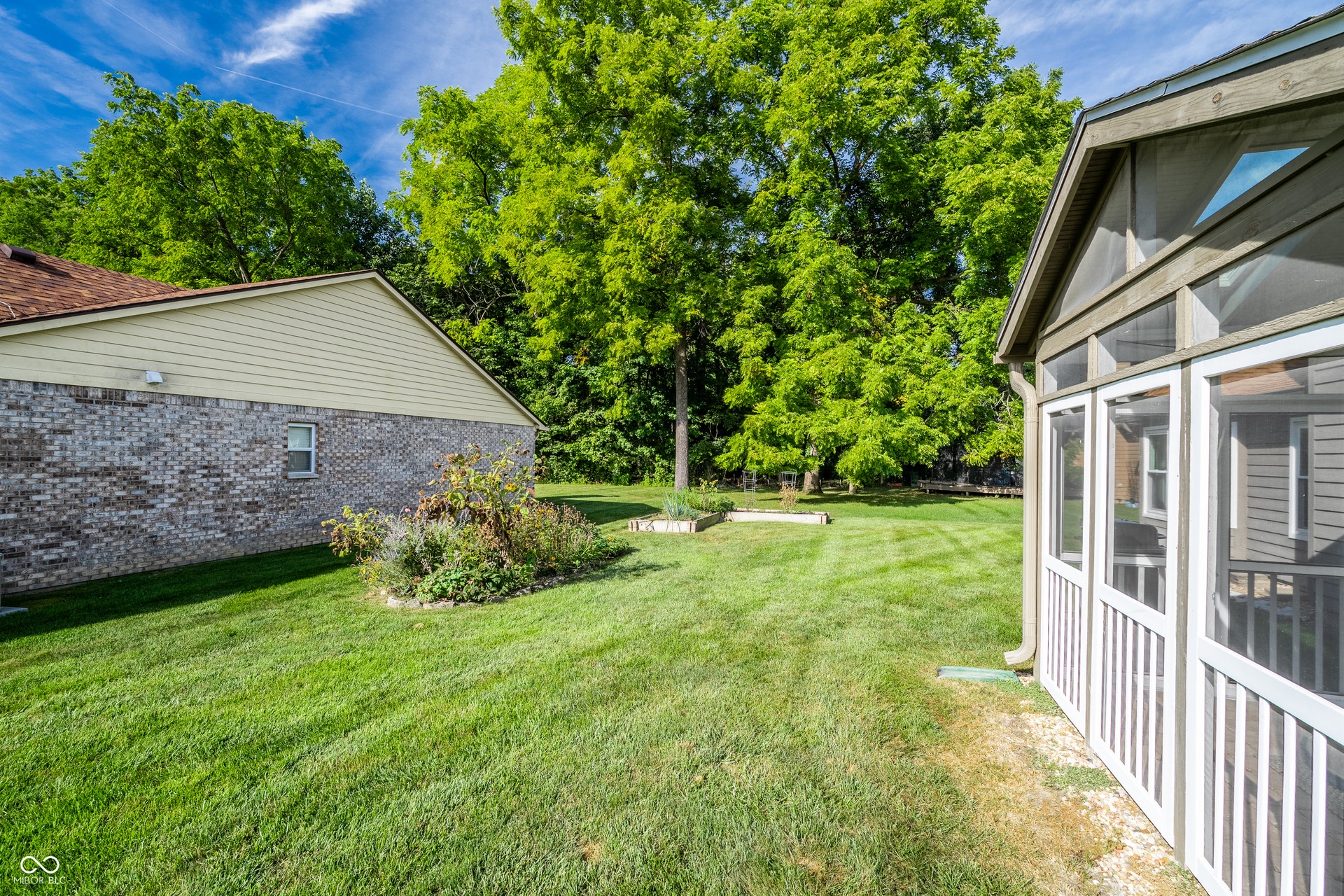 Raised garden beds and seasonal perennial flower bed in backyard