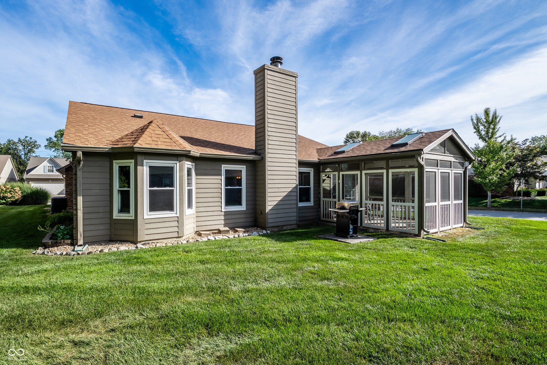 SW corner view, Expansive green lawn, screened porch, bay window, prominent chimney