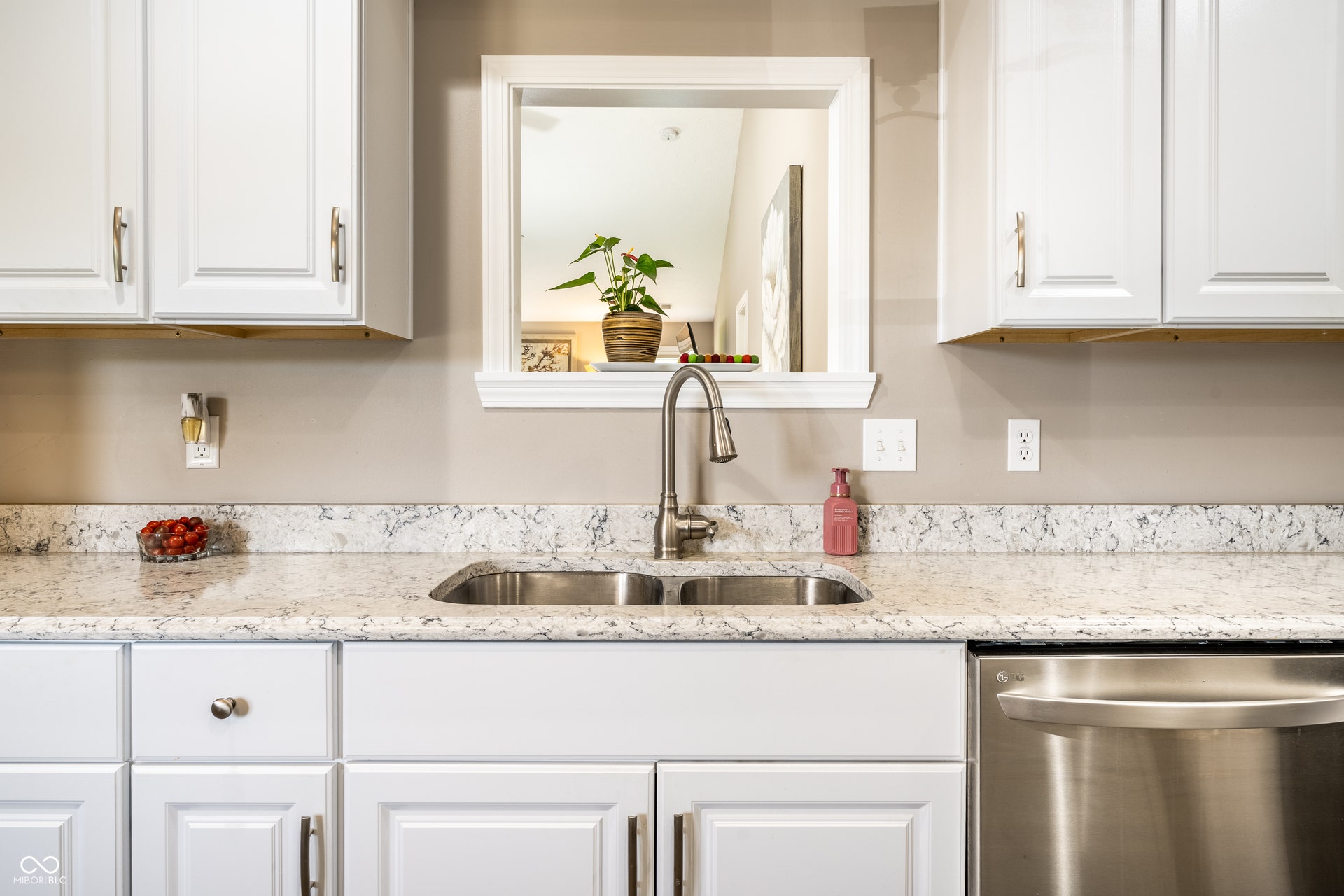White cabinetry with brushed nickel hardware, stainless steel sink with gooseneck faucet, light-toned quartz countertops, and stainless steel dishwasher