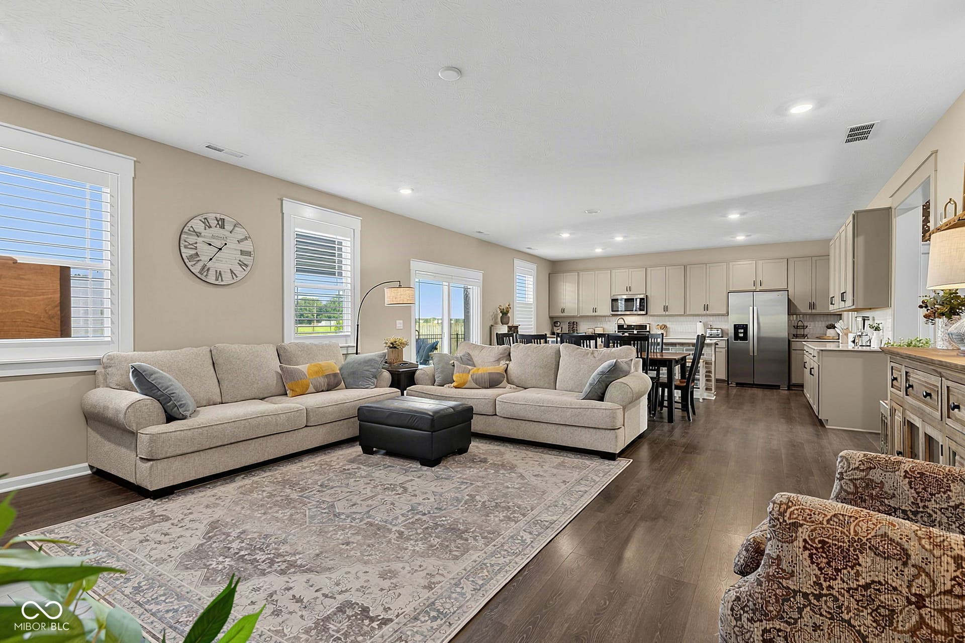 Open-concept living area with dark wood-finish flooring, recessed lighting, and ample natural light from multiple windows