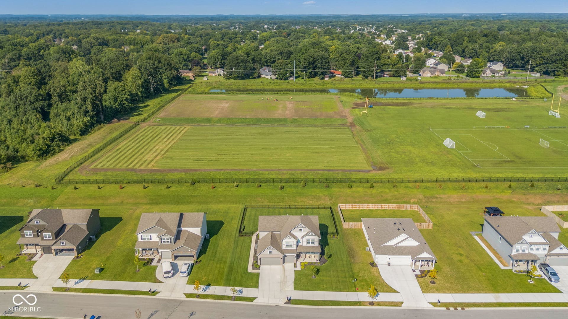 Expansive green spaces and mature trees surround this residential area