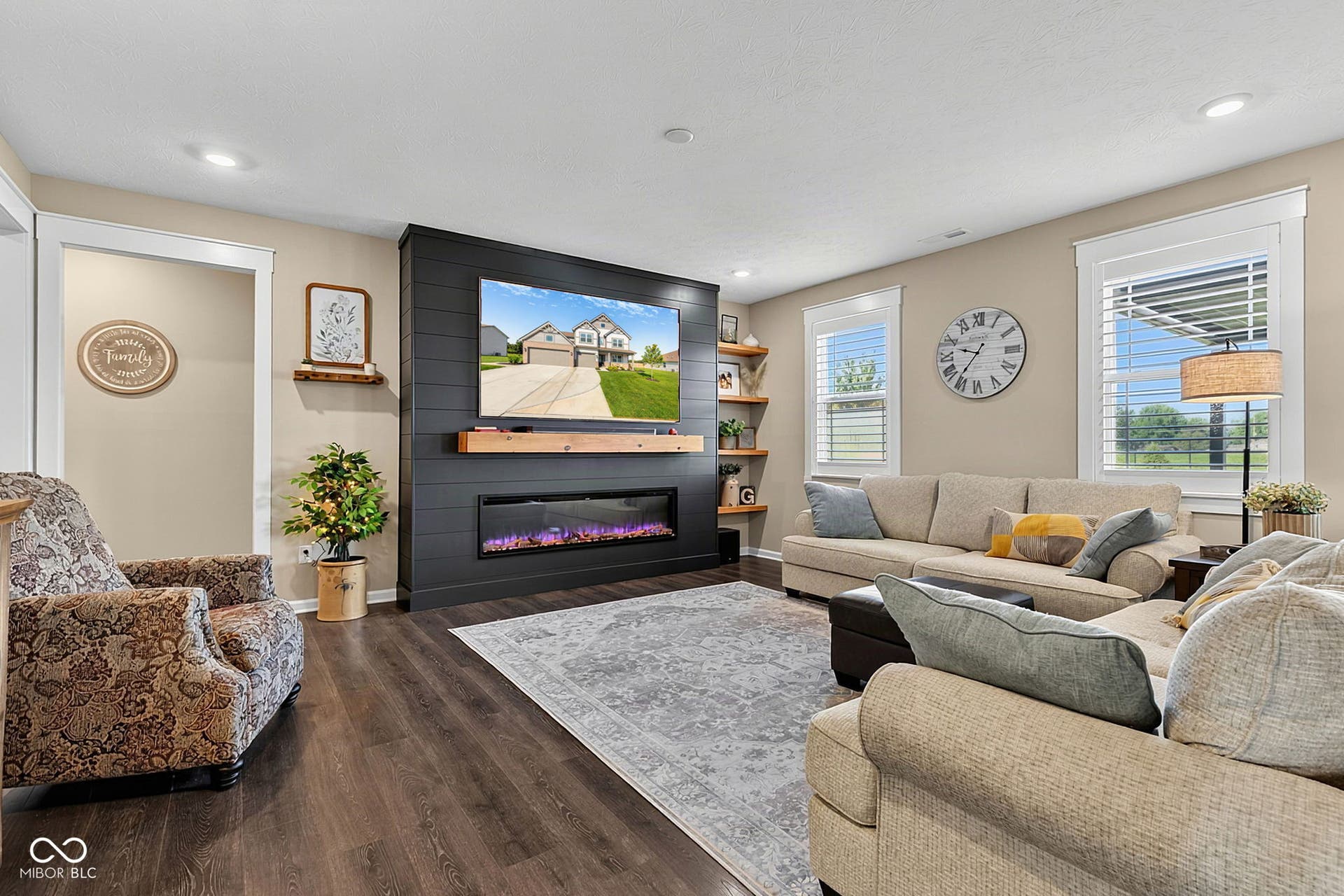 Dark wood-finish flooring, recessed lighting, and a feature wall with an electric fireplace