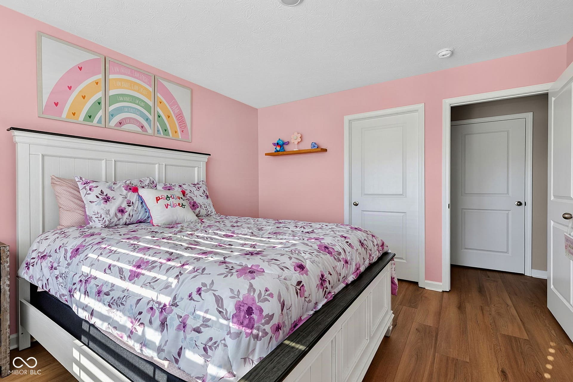 Warm wood-finish flooring complements the light wall color