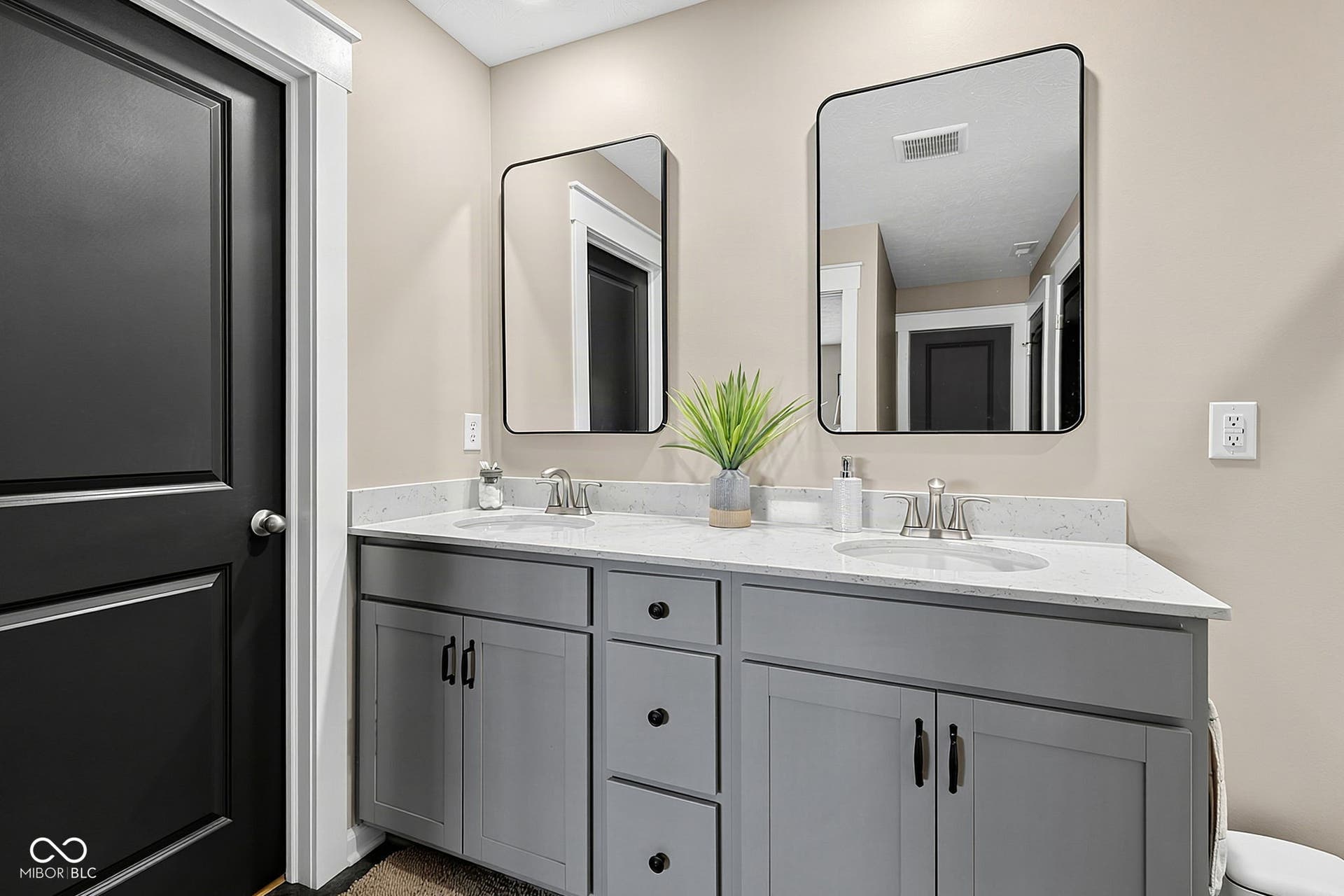 Dual vanity with light gray cabinetry, white countertops, and undermount sinks