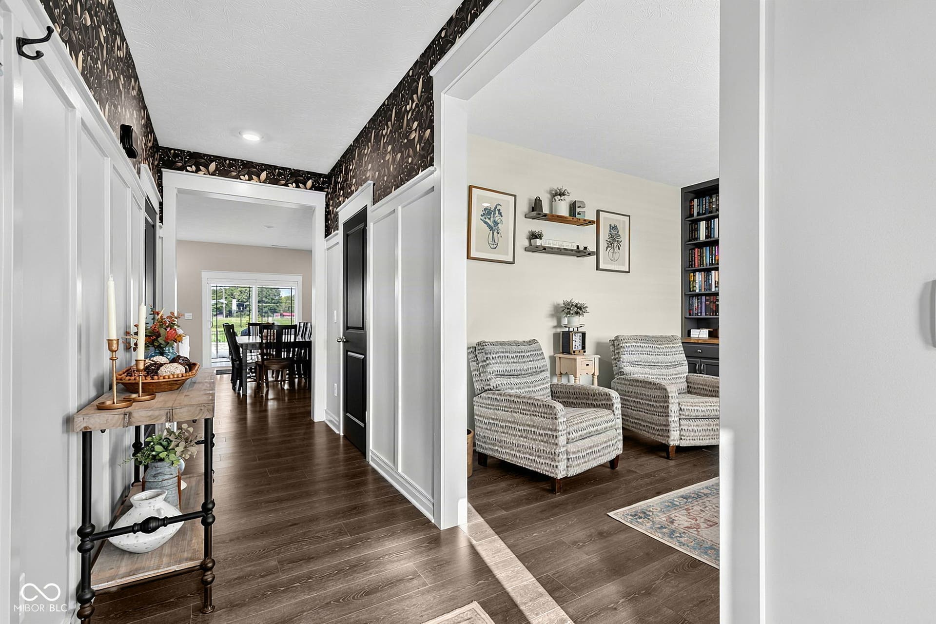 Wood-finish flooring throughout, white paneled walls, and dark accent walls