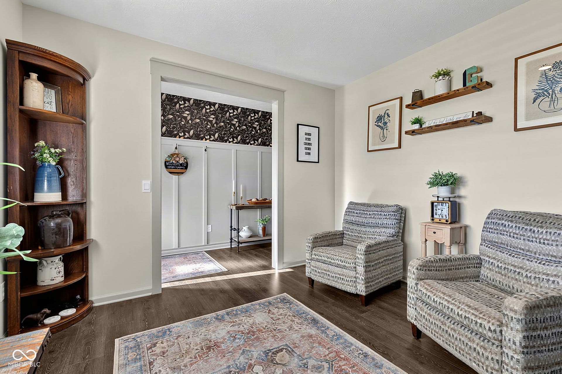 Wood-finish flooring throughout, featuring a corner built-in shelving unit, and an open doorway with trim detail