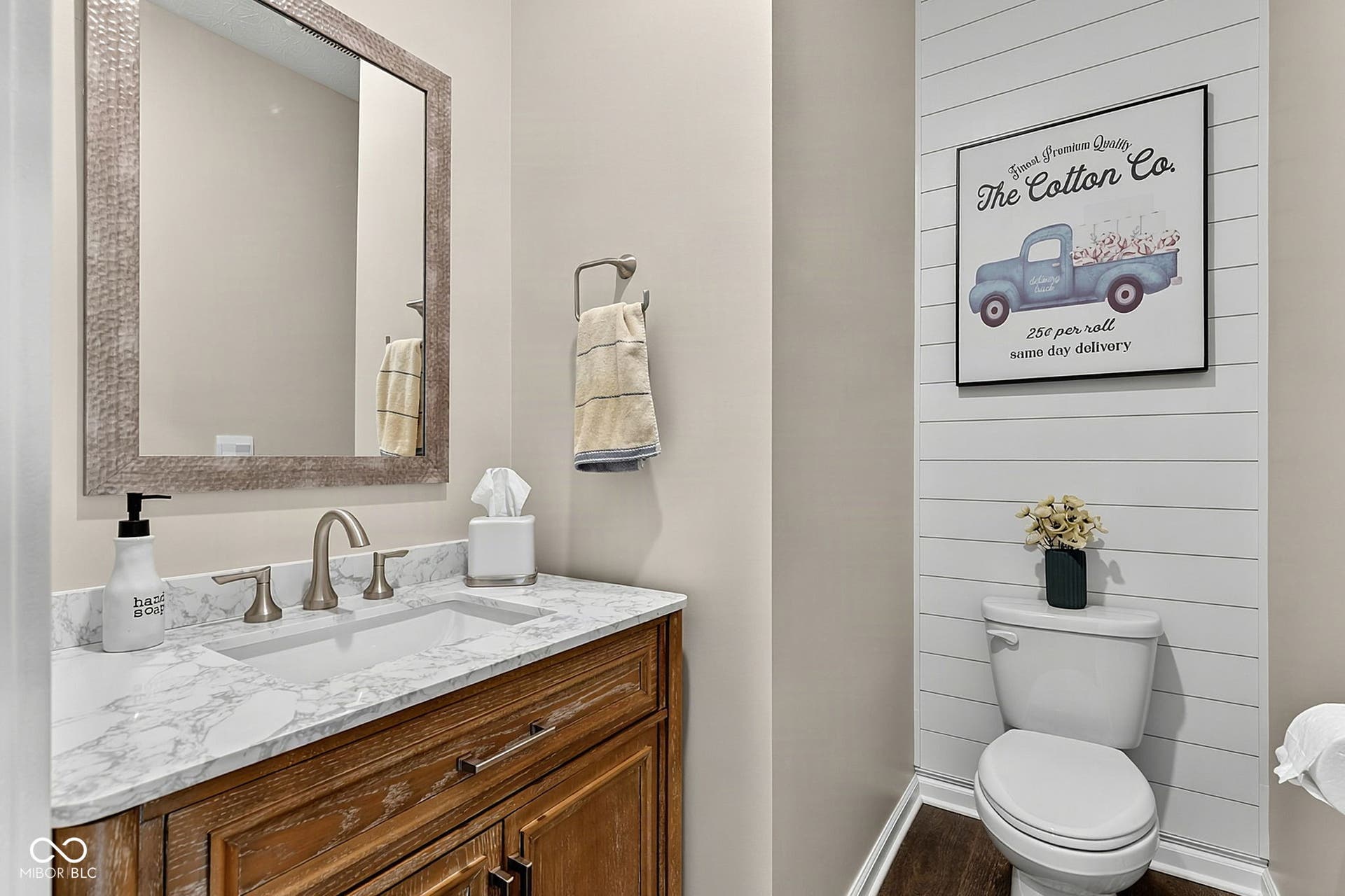 Wood-finish vanity with a rectangular undermount sink, stone countertop, and brushed nickel faucet