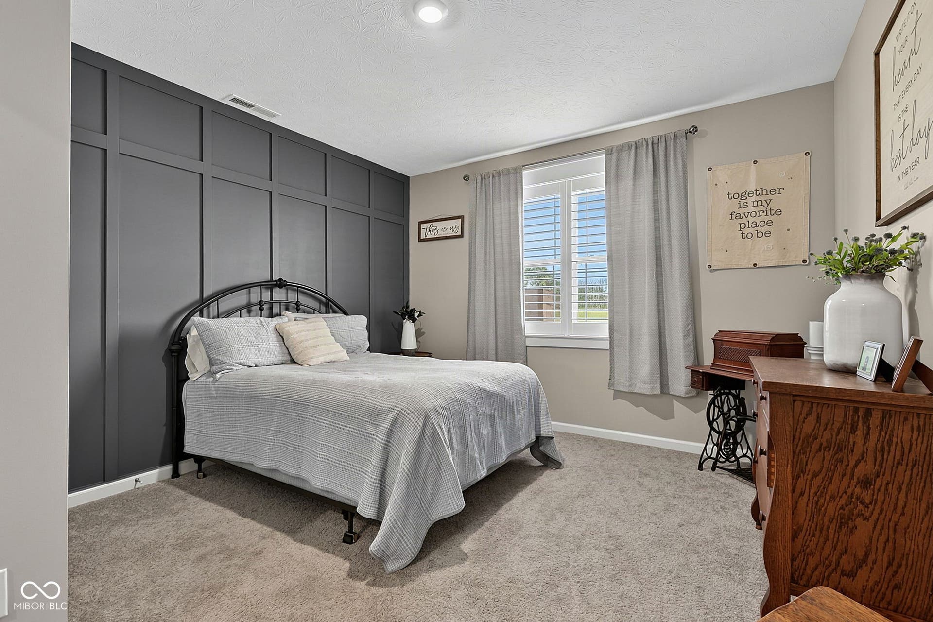 Feature wall with wainscoting detail, neutral-toned carpeting, window with plantation shutters, recessed ceiling lighting, and crown molding