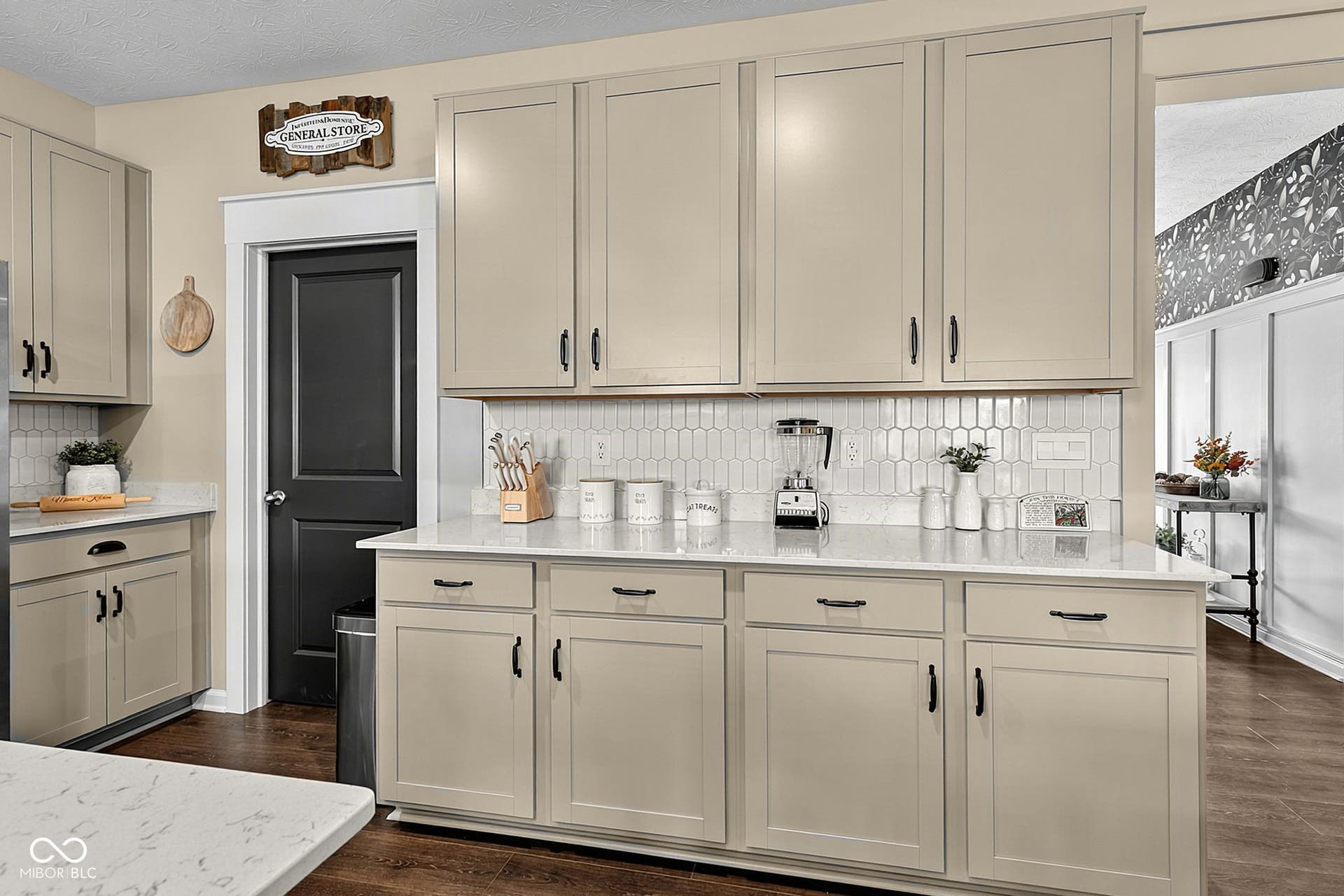Shaker-style cabinetry with matte black hardware, white countertops, and a white picket tile backsplash