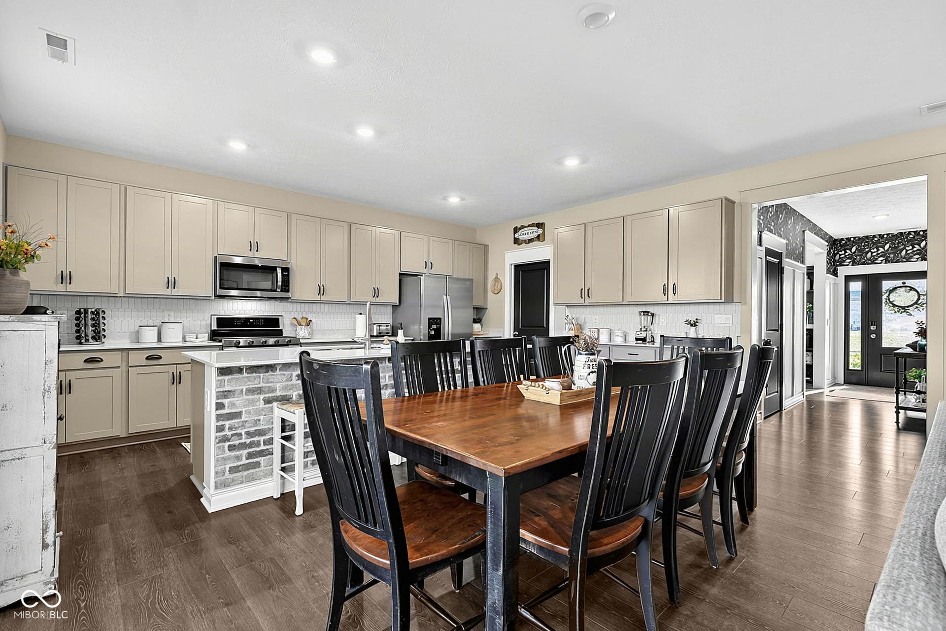Kitchen with neutral-toned cabinetry, stainless steel appliances, and a tiled backsplash