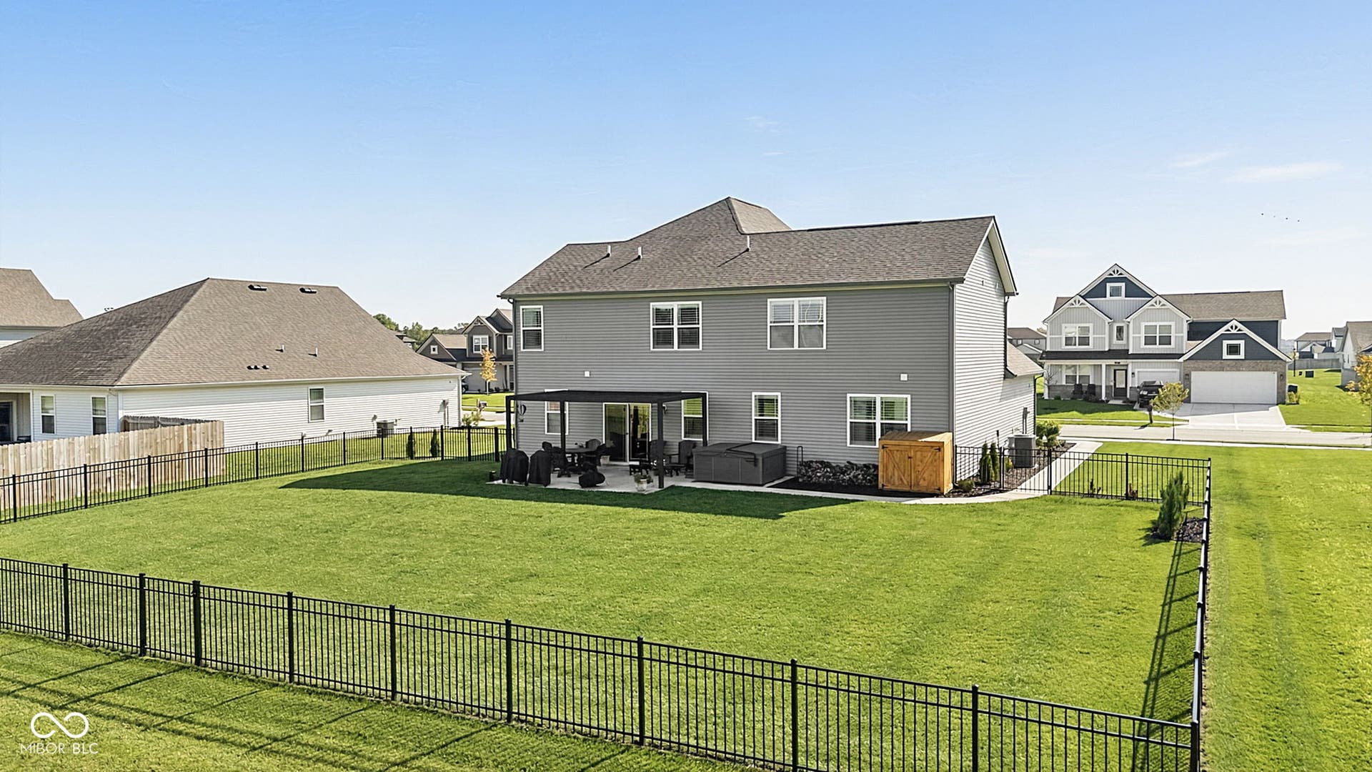 Expansive fenced backyard with a patio featuring a pergola