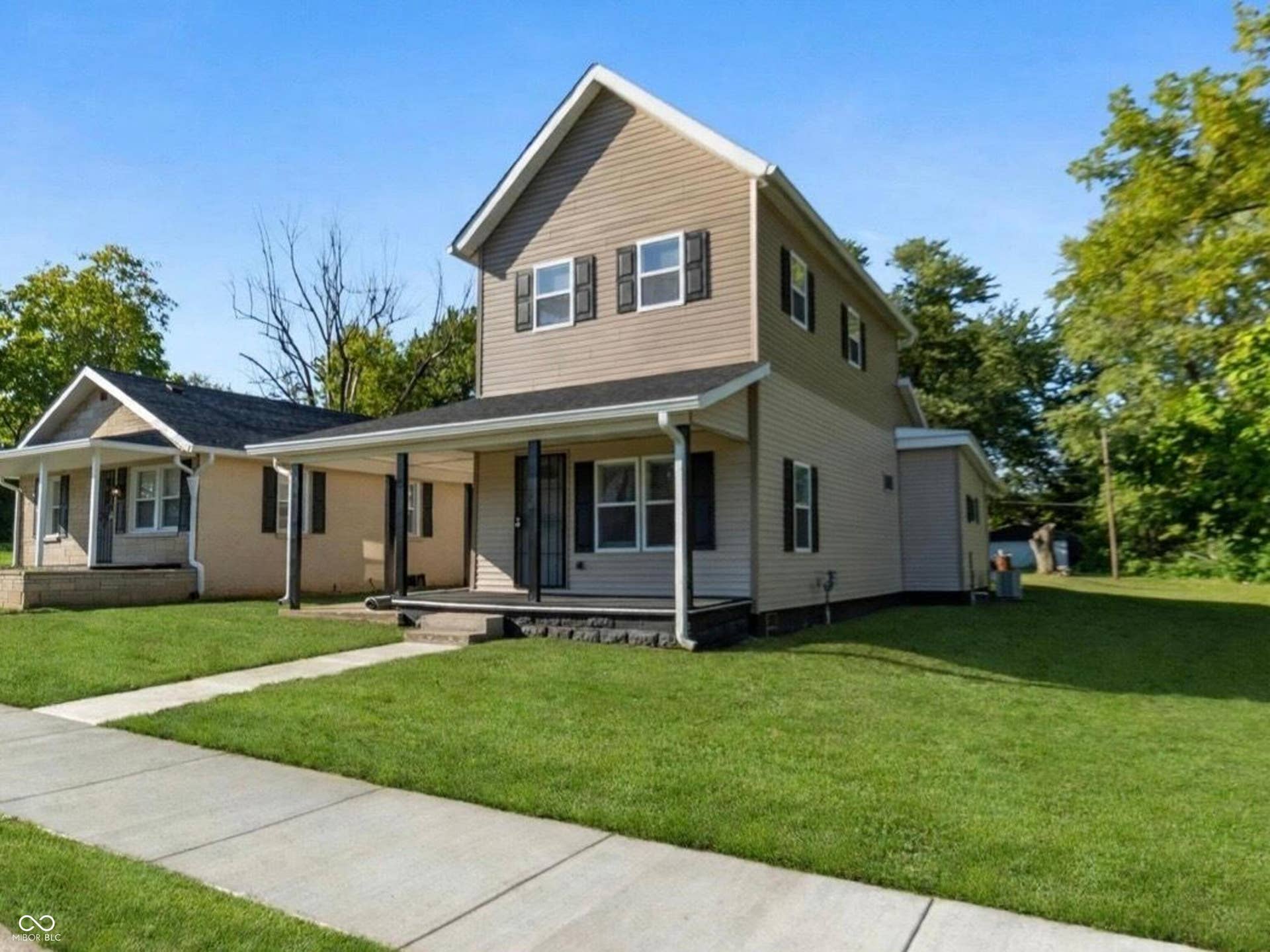 Two-story exterior with light-colored siding and dark shutters