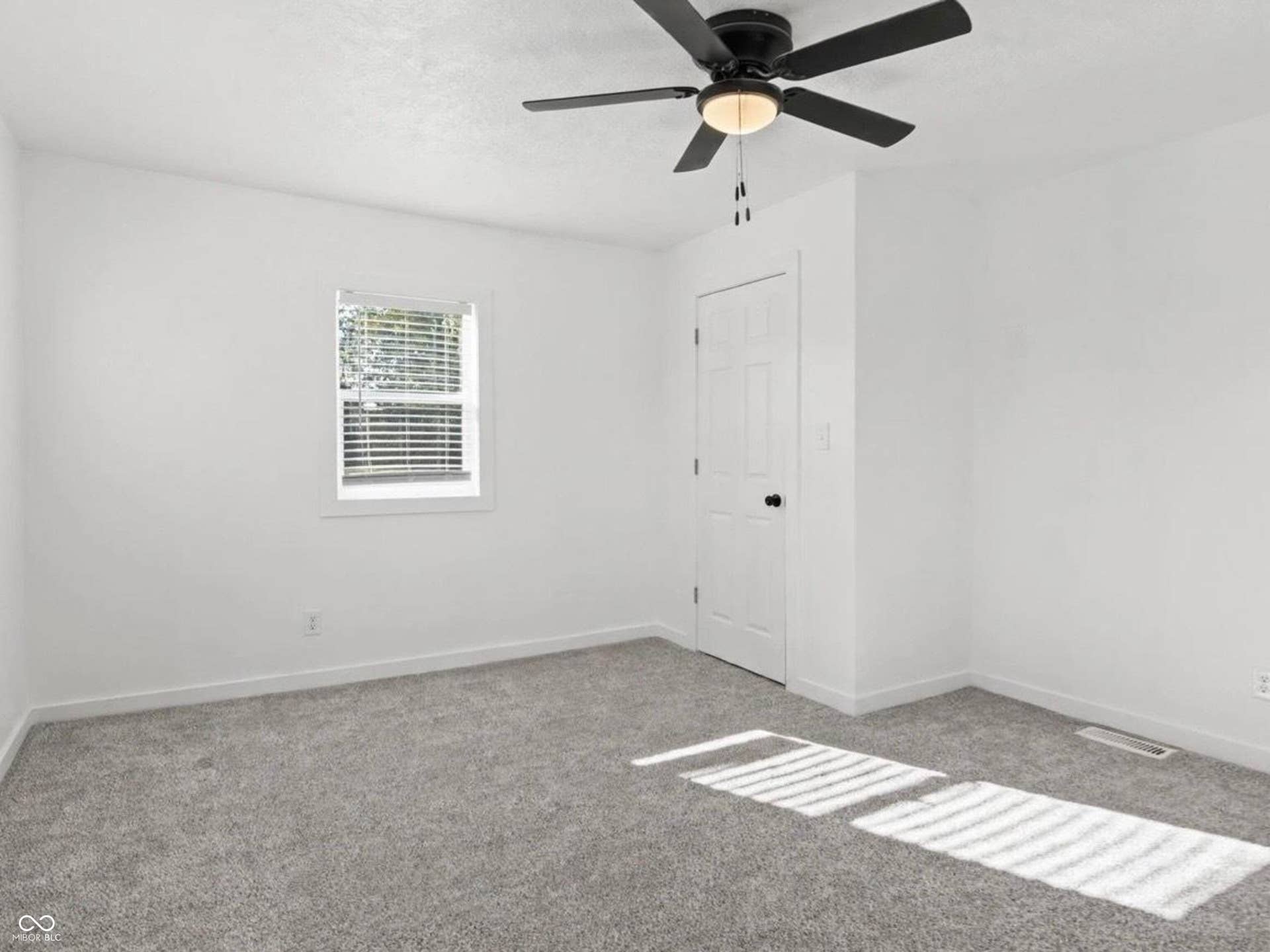 Neutral wall paint, gray carpet flooring, ceiling fan with integrated lighting, white interior door, and window with blinds