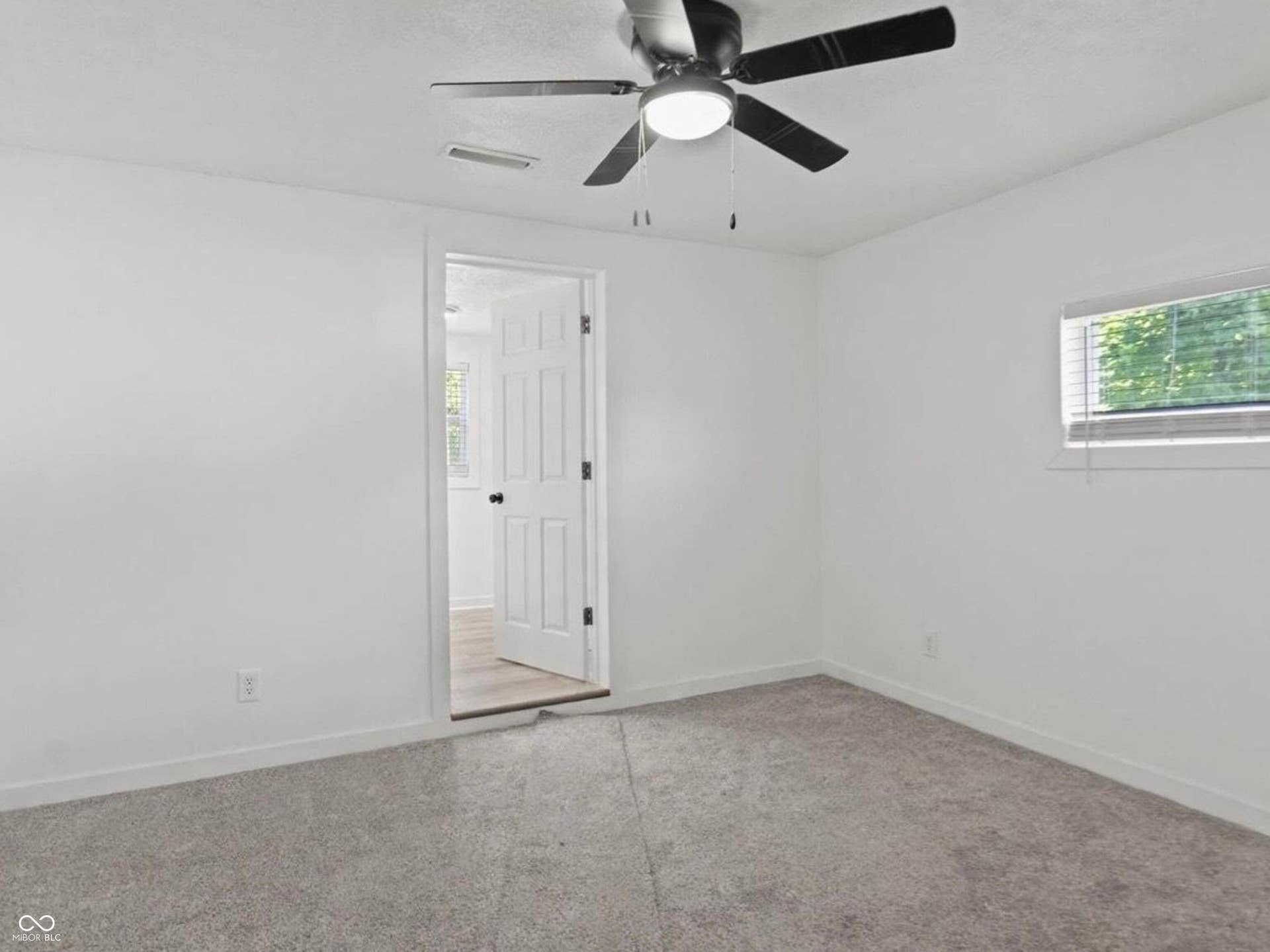 Recessed lighting, ceiling fan with integrated lighting, window with blinds, paneled interior door, and grey carpeting
