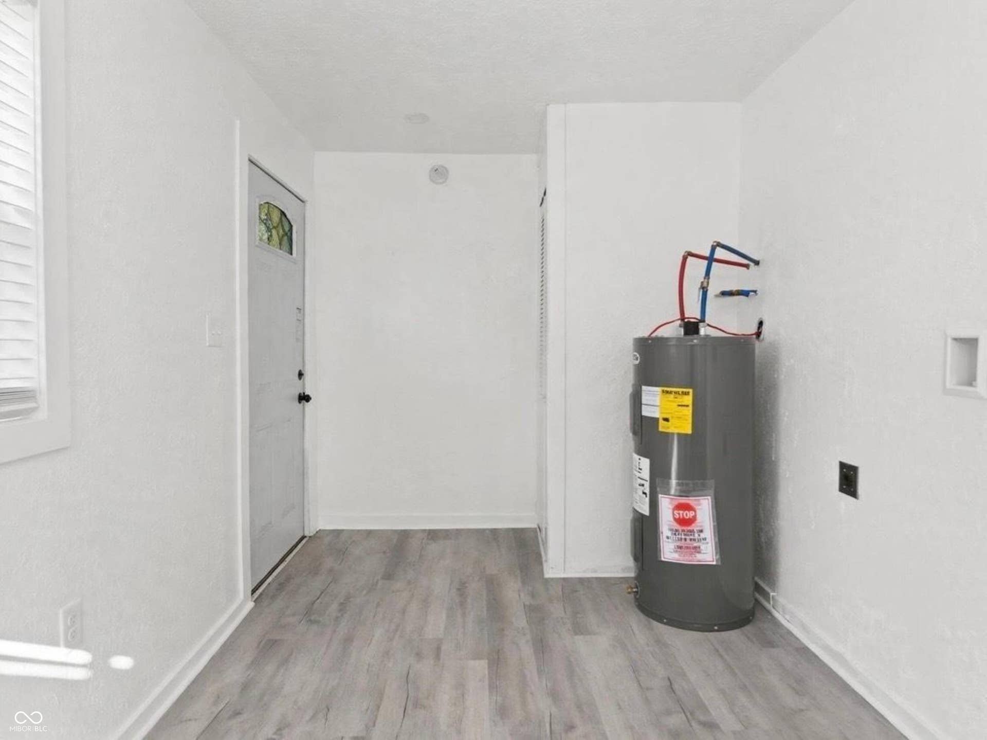 Utility area featuring a water heater, laundry hookups, and wood-finish flooring