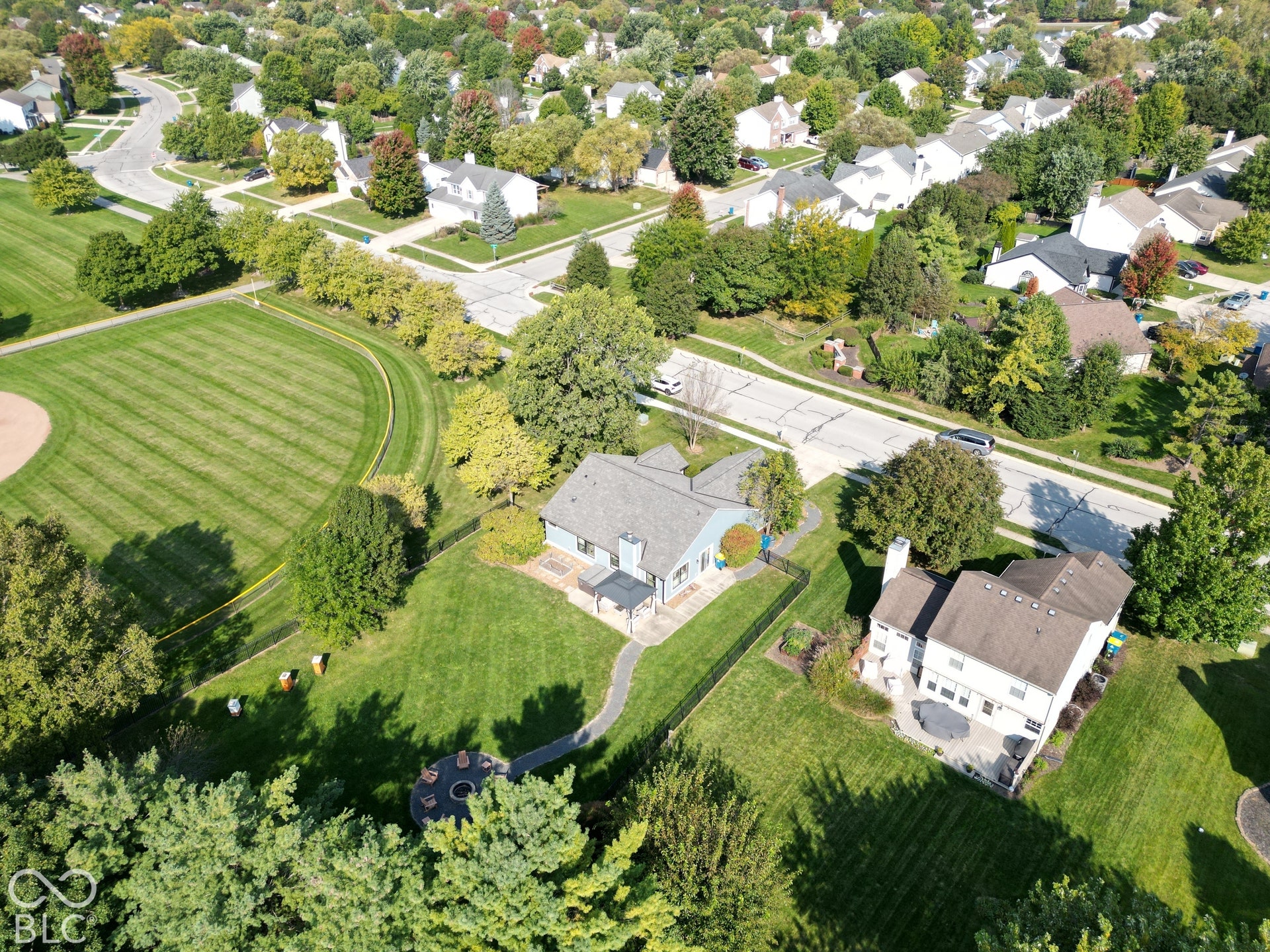 Expansive landscaped property with mature trees, a private patio, and a stone walkway