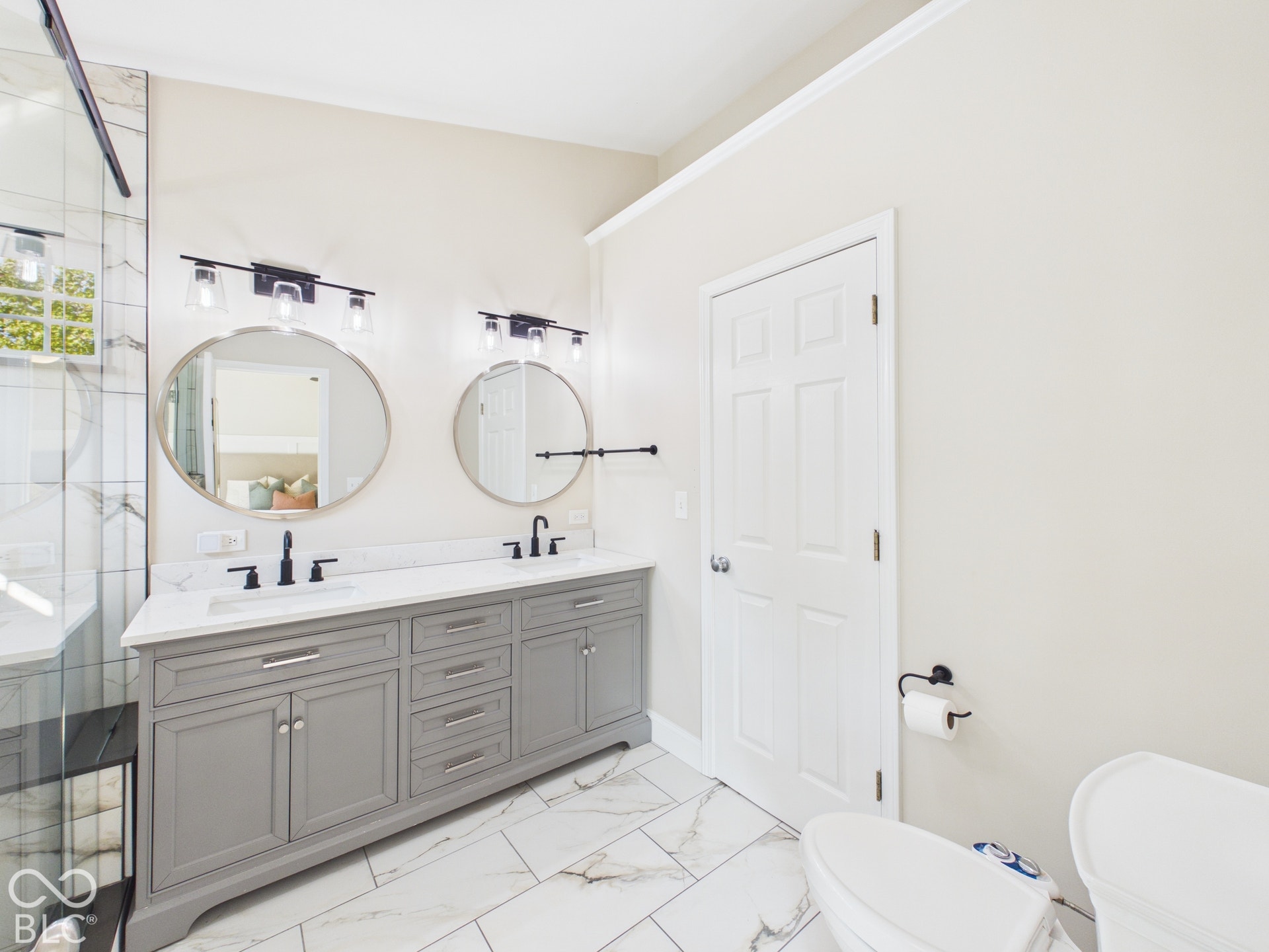 Dual vanity with gray cabinetry, white countertops, and matte black fixtures