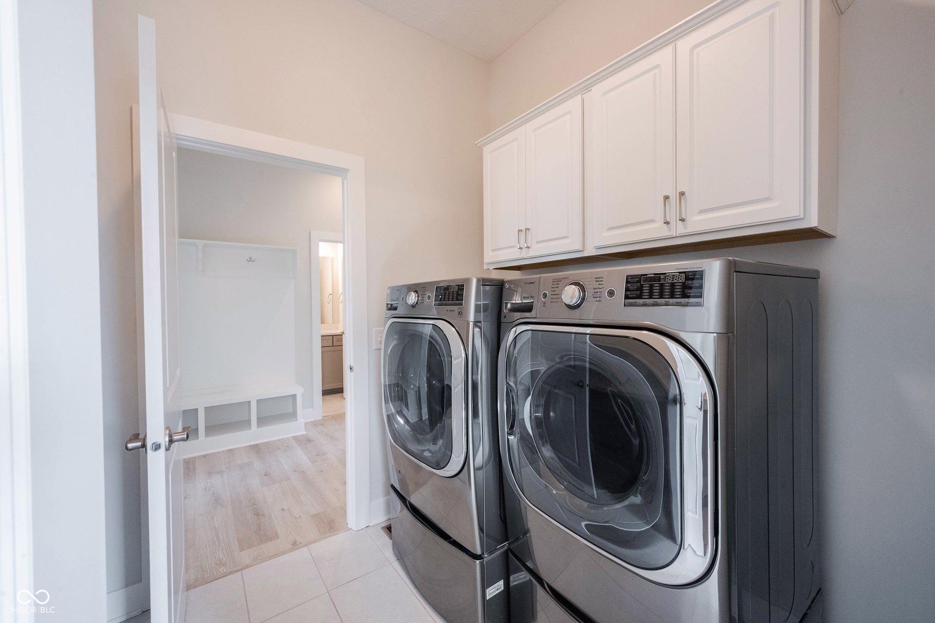 Laundry room with cabinetry, folding station and the washer and dryer convey.